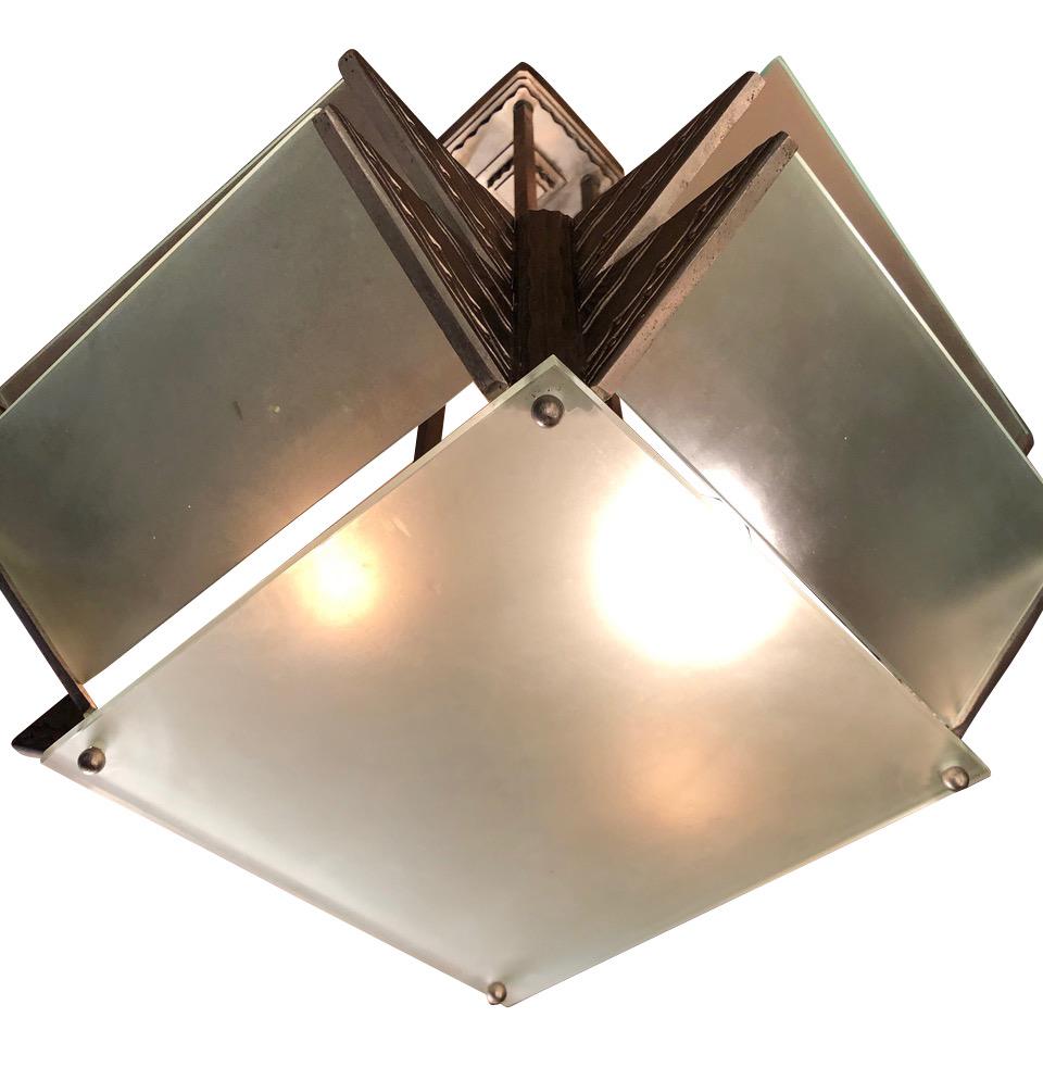 Art Deco modernist chandelier with a very cubist or geometric point of view. Unusual design featuring angular metal details held together with simple frosted glass. French design circa 1930s with both openings for light and heat. Not intended for