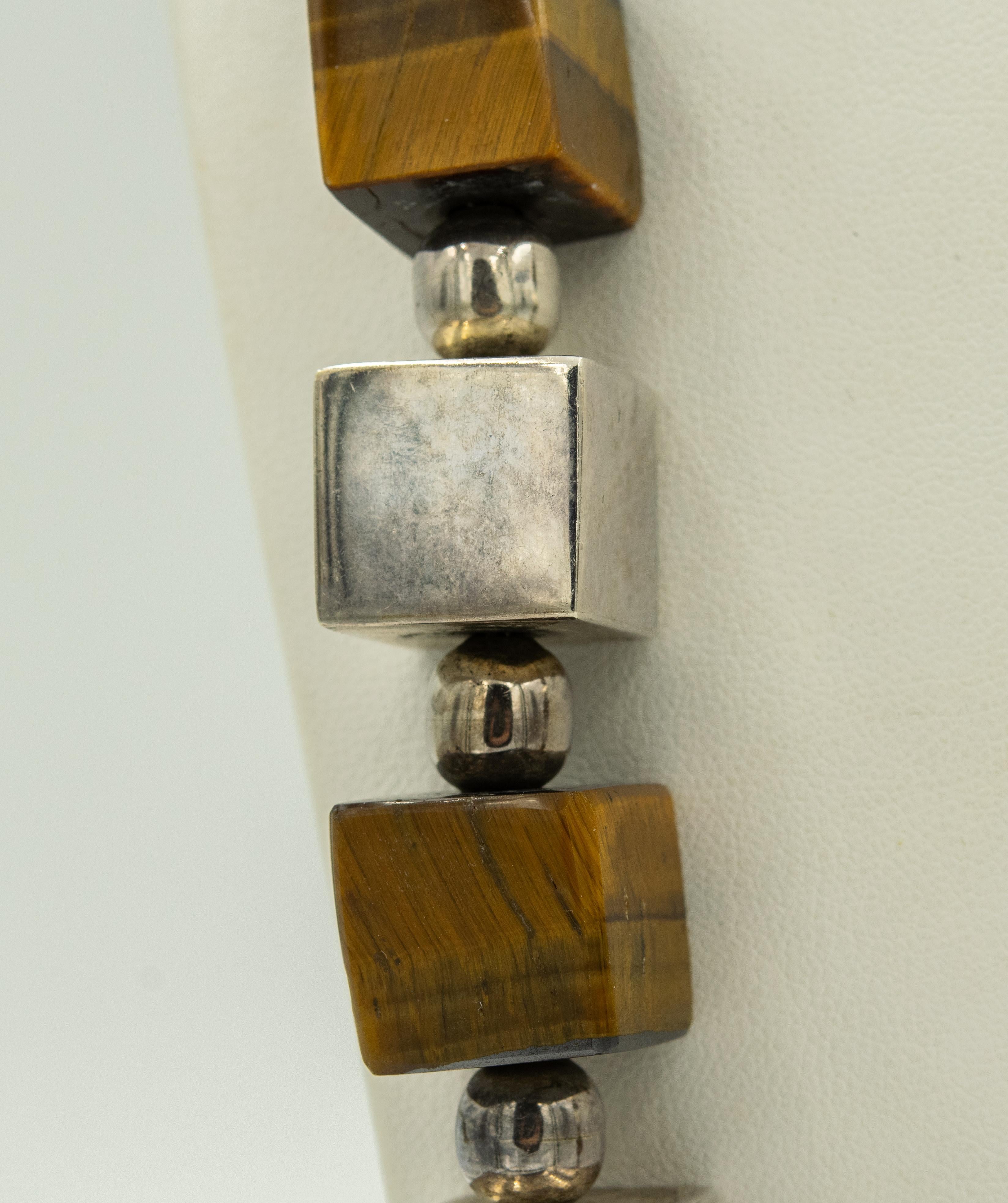 Late 20th century Mexican modernist necklace featuring different sized sterling silver square cubes, circles and tiger's eyes cubes.  The piece is 28.5