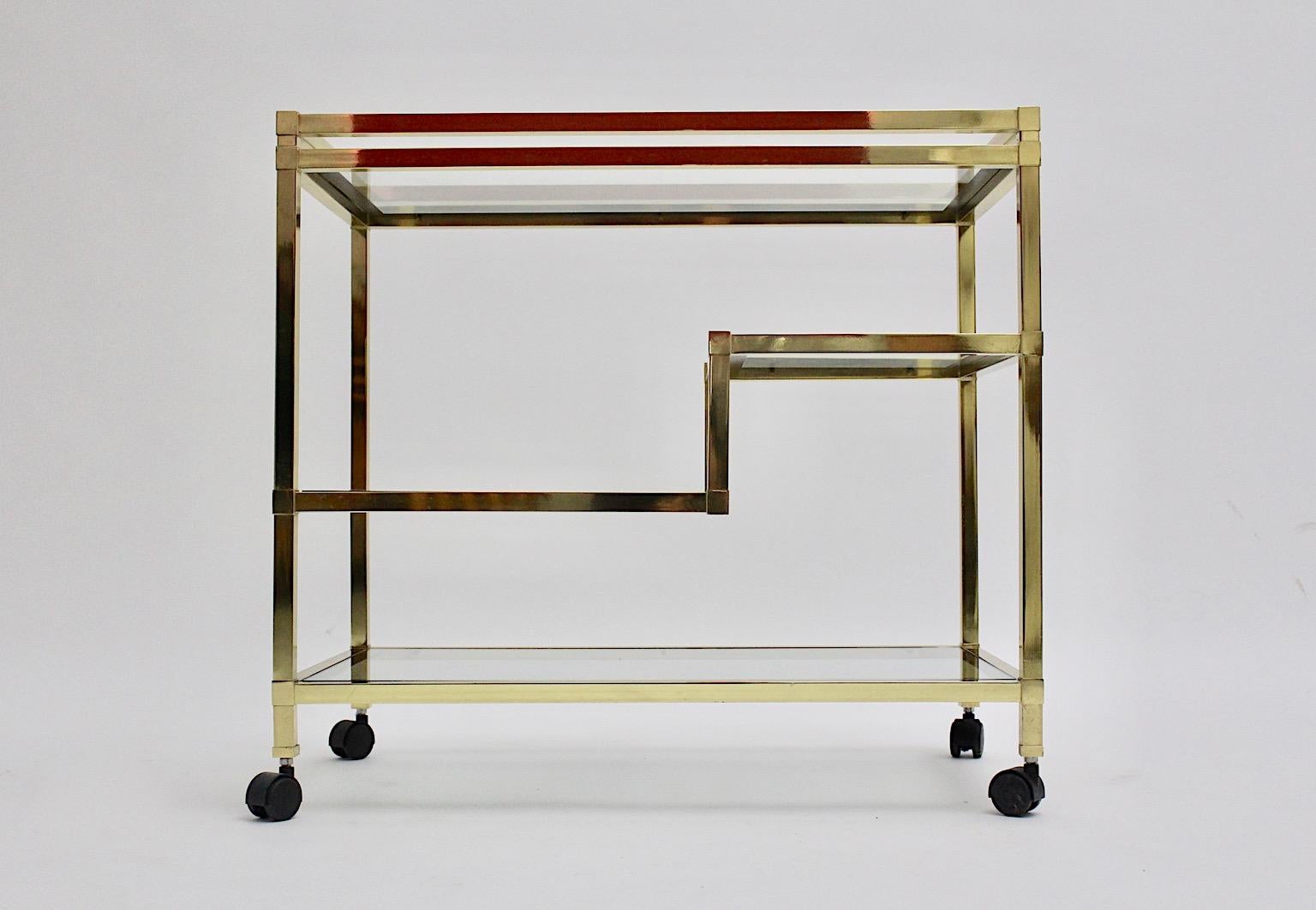 Carrito de bar modernista geométrico vintage de metal dorado y cristal transparente años 70 Italia.
Un fabuloso carrito de bar al estilo de Romeo Rega que consiste en una construcción de marco dorado con cuatro placas de cristal de varios tamaños,