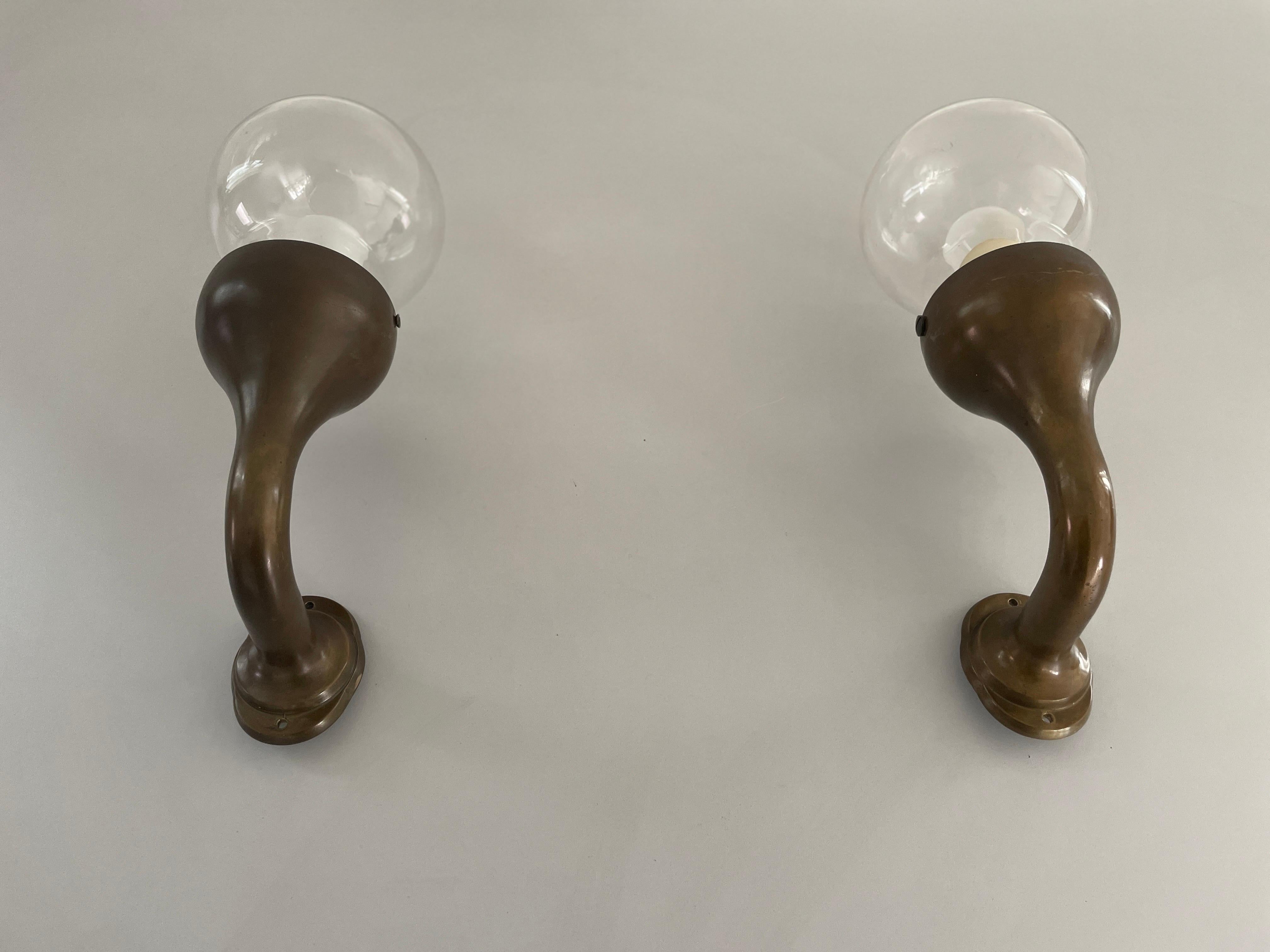 Modernist Glass and Bronze Body Pair of Sconces, 1960s, Italy

Very elegant and Minimalist wall lamps.

Lamps are in excellent condition.

These lamps works with E14 standard light bulbs. 
Wired and suitable to use in all countries. (110-220