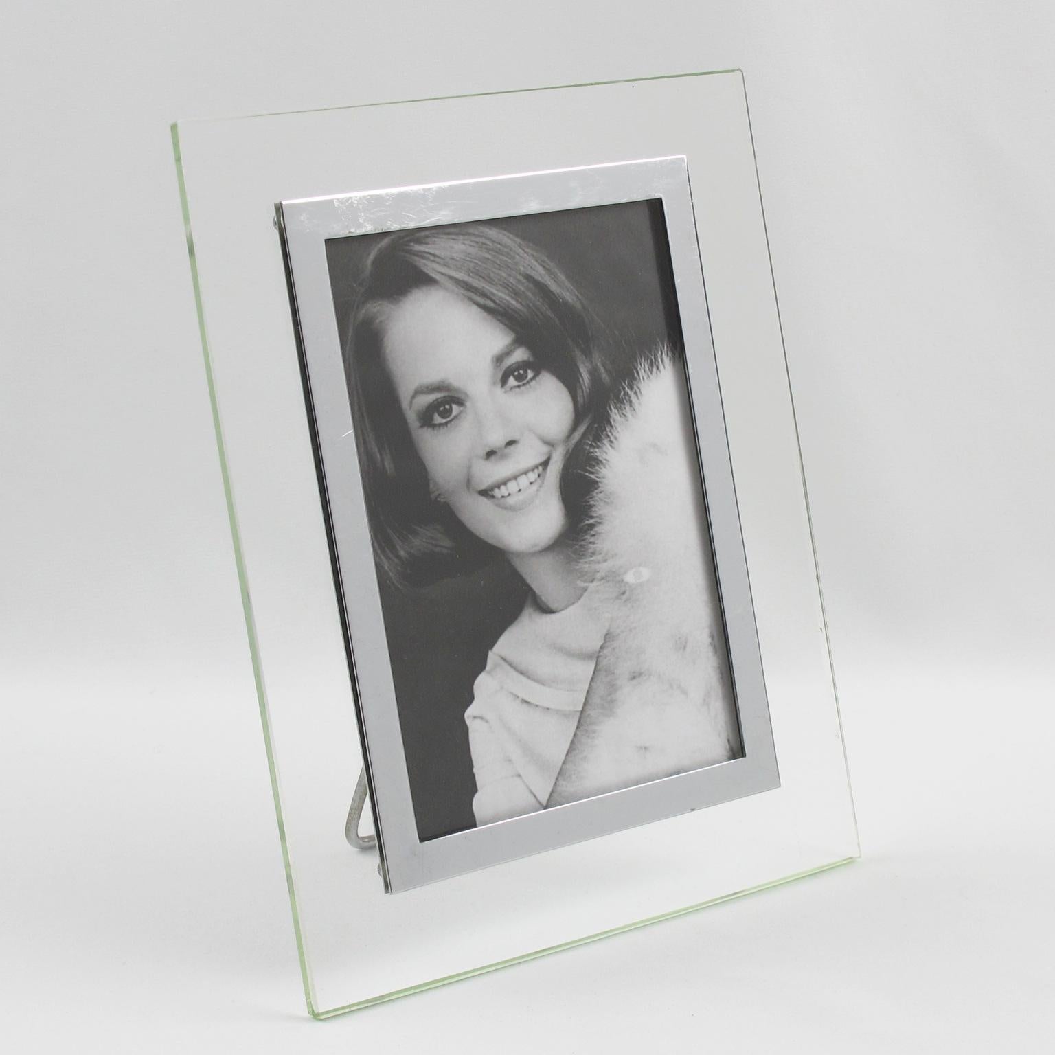 This stunning French glass picture frame features a transparent glass slab with a geometric design and refined, chromed metal framing that surrounds the picture view. The photo frame was crafted in France circa 1940. A metal easel at the back keeps