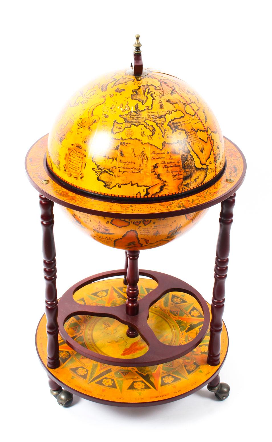 This is a modernist midcentury cocktail drinks cabinet in the form of a globe, circa 1960 in date.

The hinged top section opens to reveal a fitted interior with spaces for glasses and a ice bucket. The turned tripod legs are joined by an