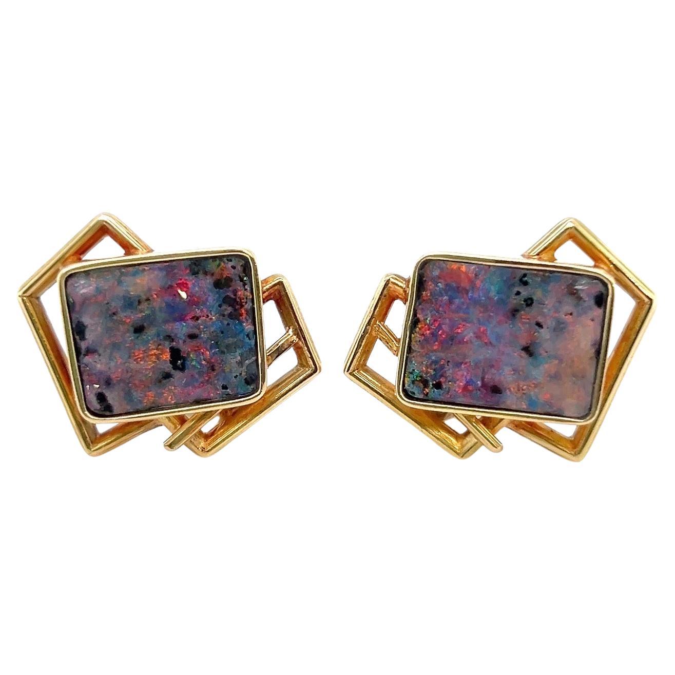 Dazzling pair of modernist gold and opal earrings.

Crafted in 14 karat yellow gold, pair of geometrically designed ear clips set with 2 rectangular opal platelets of natural, wavy surface. The opals display a lively red, green and blue play of