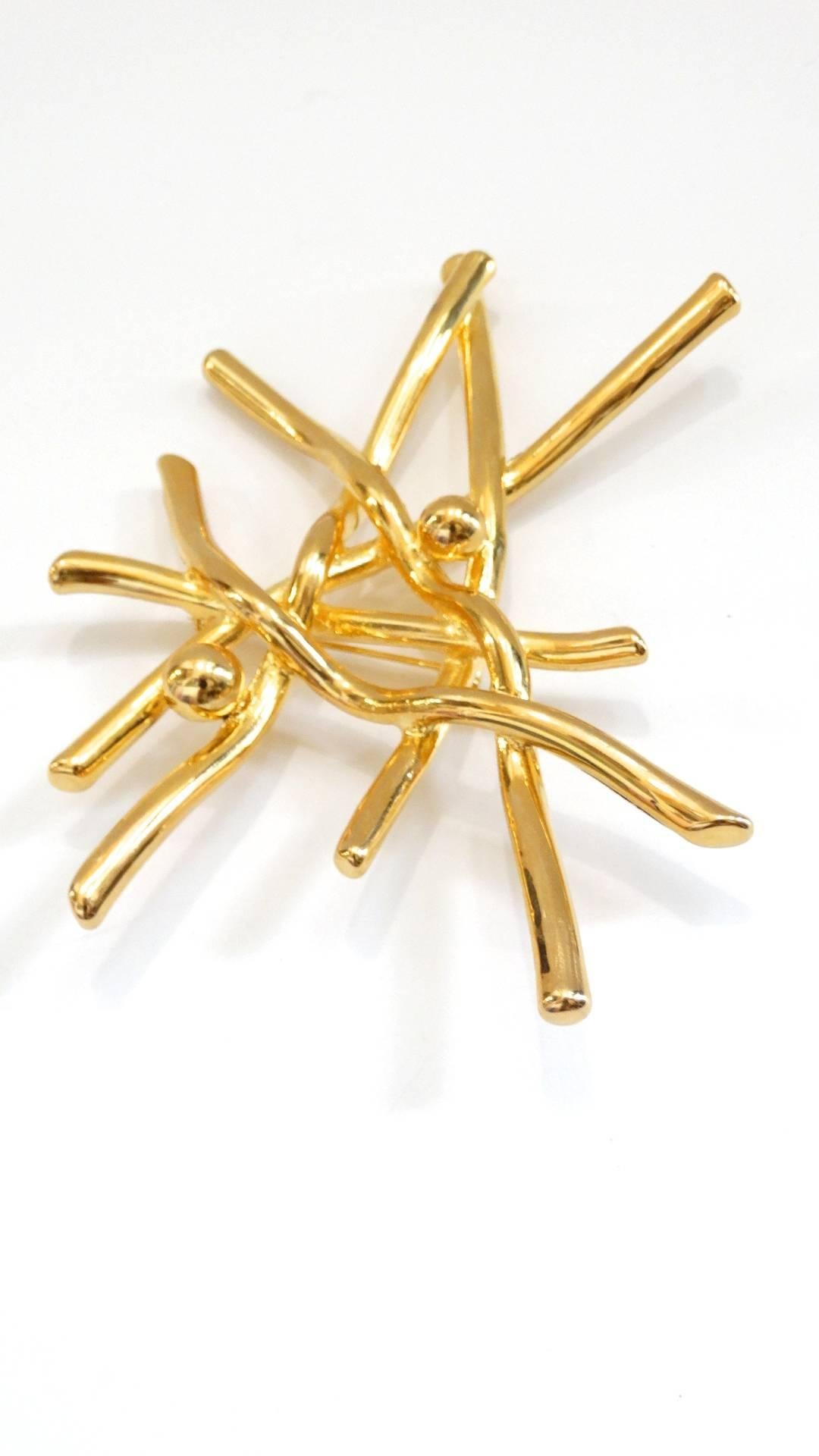Show your appreciation for the modernist movement with this incredible 1980s gold plated brooch! Minimalist design, branch like design with two ball embellishments at either side. Plated with a brilliant gold, this piece looks amazing contrasted on