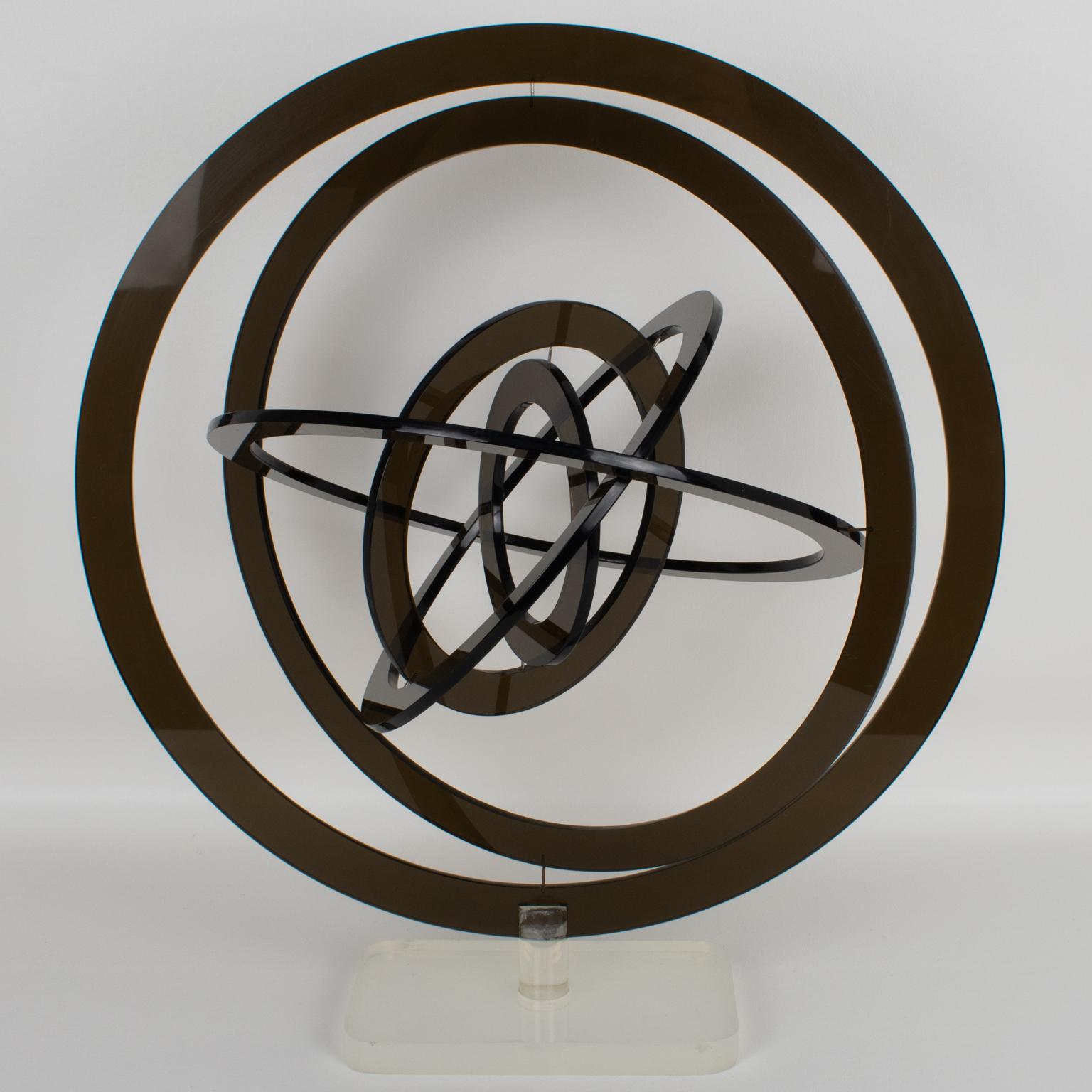 This stunning rotating kinetic sculpture was crafted in Italy in the 1970s. The six circles are made of Lucite in a smoke gray color and stand on a frosted clear Lucite base. The six concentric circles that constitute this astrolabe pivot on a