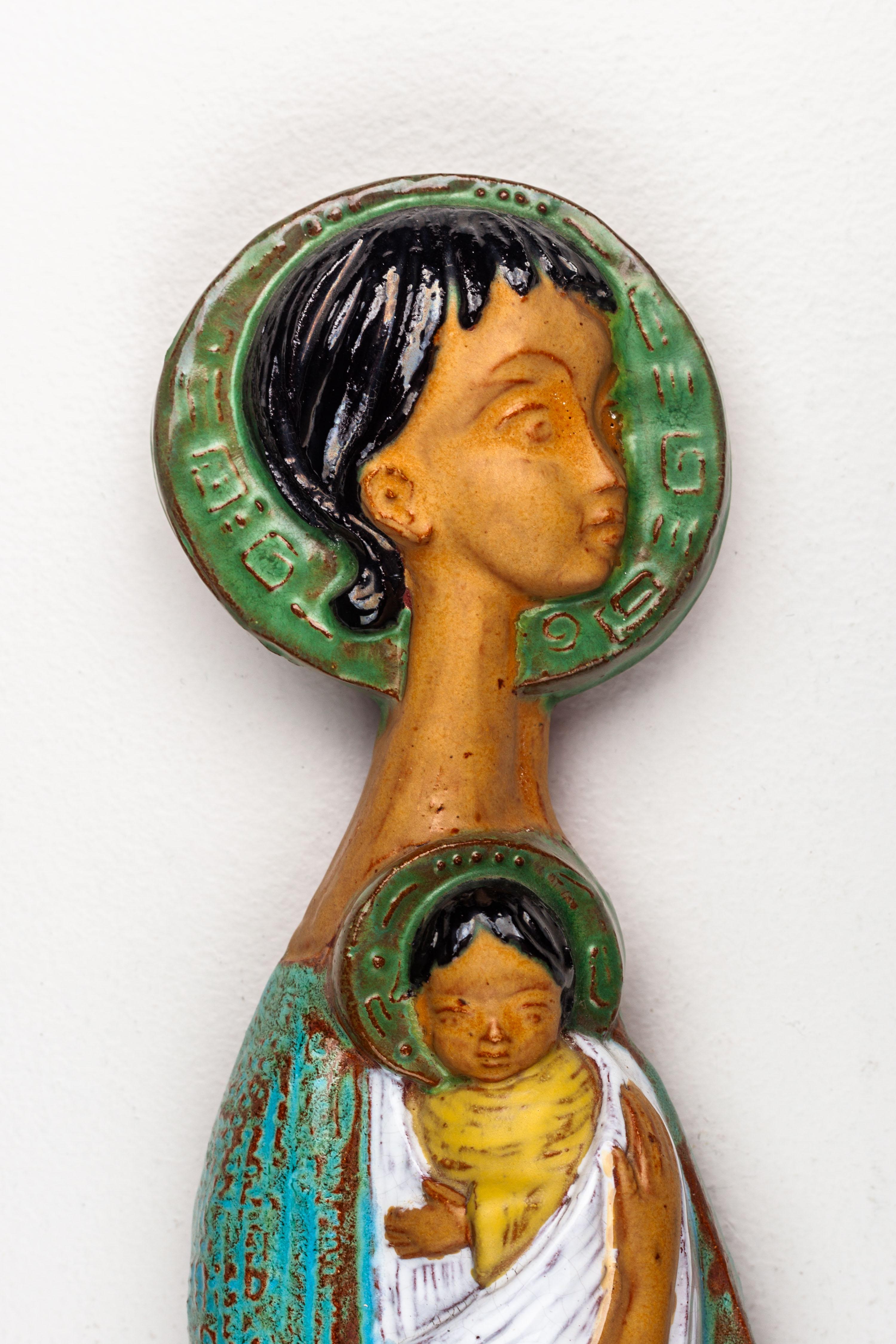 This 16-Inch ceramic wall decoration, crafted by a European Modernist Studio Pottery artist, showcases a Mediterranean color palette: terracotta, turquoise blue, and olive green shades in shiny glazes.

The composition depicts a soft, elongated