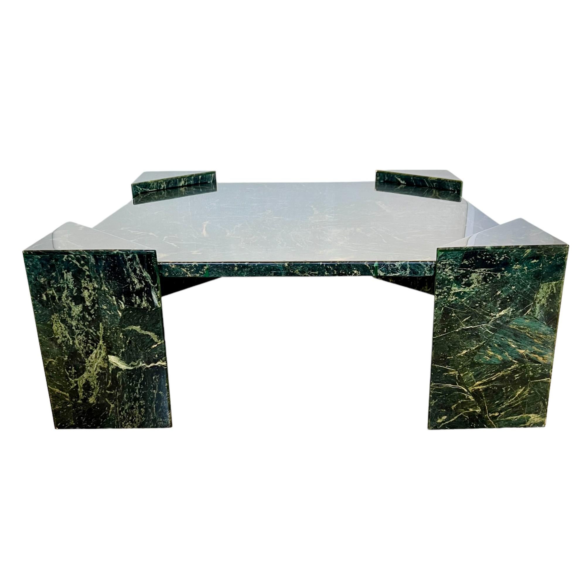 This vintage 1980's modernist style faux marble composite cocktail or coffee table has been skillfully handcrafted out of fiberglass and given a marble effect green gel coat finish with veins in tints of light green and cream. The minimalist design