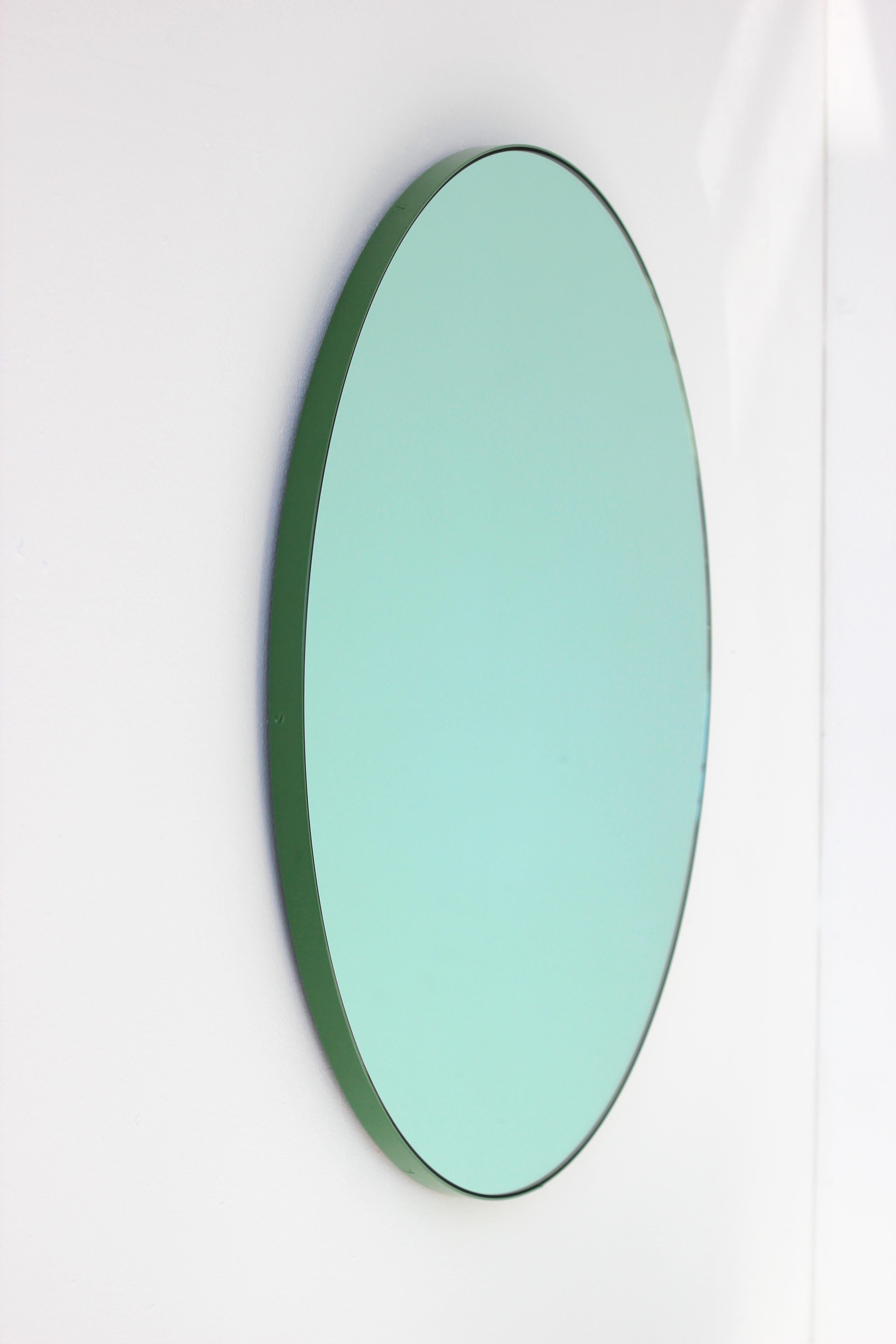 Delightful round green tinted mirror with a colorful green powder coated aluminium frame. Designed and handcrafted in London, UK. 

Fitted with a brass hook or an aluminium z-bar depending on the size of the mirror. Also available on demand with a