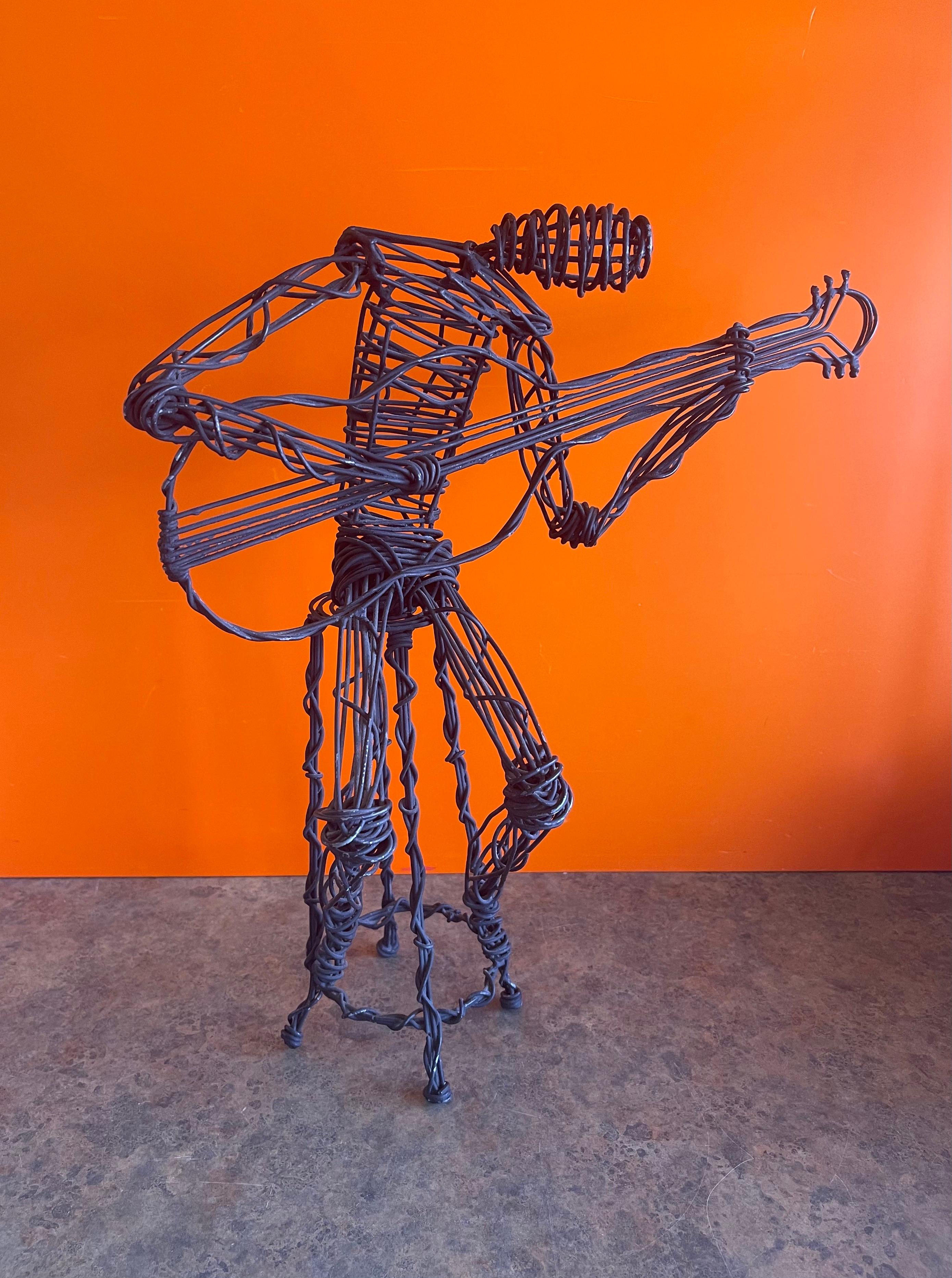 A very cool modernist musician playing guitar metal wire sculpture, circa 1970s. The piece is handmade and in very good vintage condition with a nice patina and depicts a guitarist sitting on a stool jamming away! The piece measures 8.5