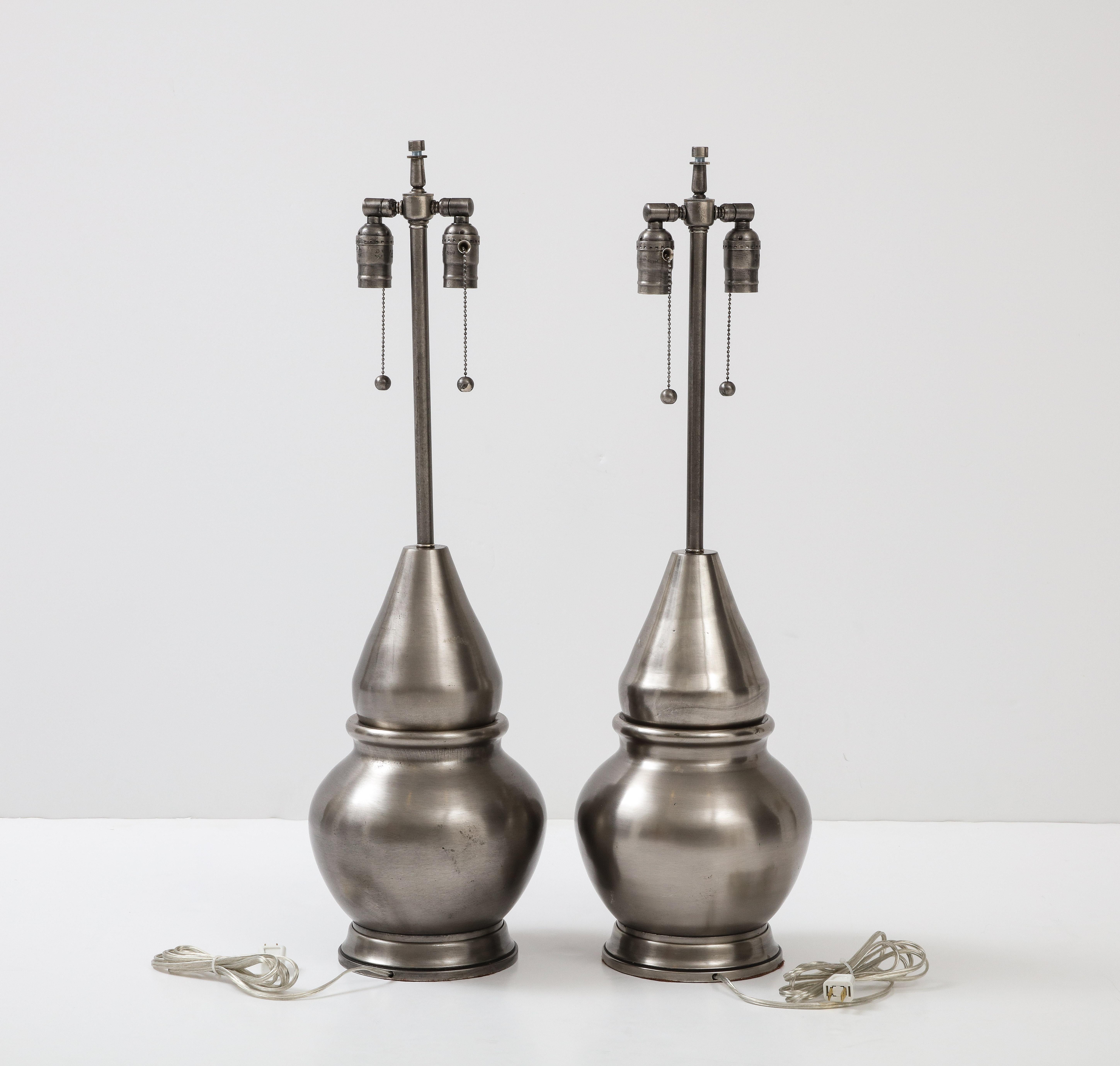 Modernist pair of custom hand turned gun metal lamps featuring a moorish/turret design. Lamps have a seductive Tahitian black pearl color. Rewired for use in the USA with double pull chain sockets. 100W max bulbs.