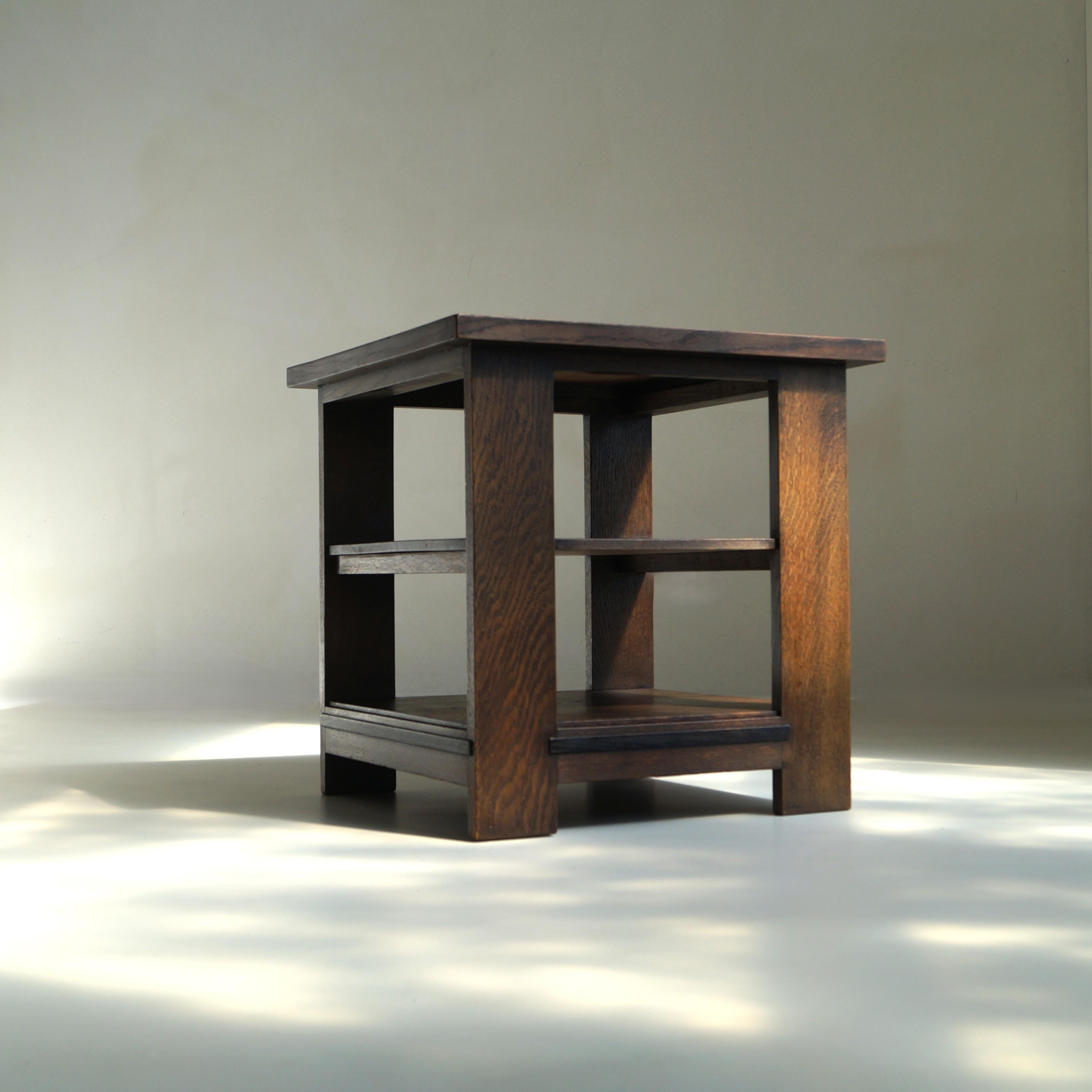 Table d'appoint à trois niveaux en chêne teinté, fabriquée dans les années 1920 par le pionnier du mobilier néerlandais I.V.I.I. Oosterbeek. La forme rectiligne et épurée de la table est rehaussée de détails subtils de l'école de La Haye, notamment