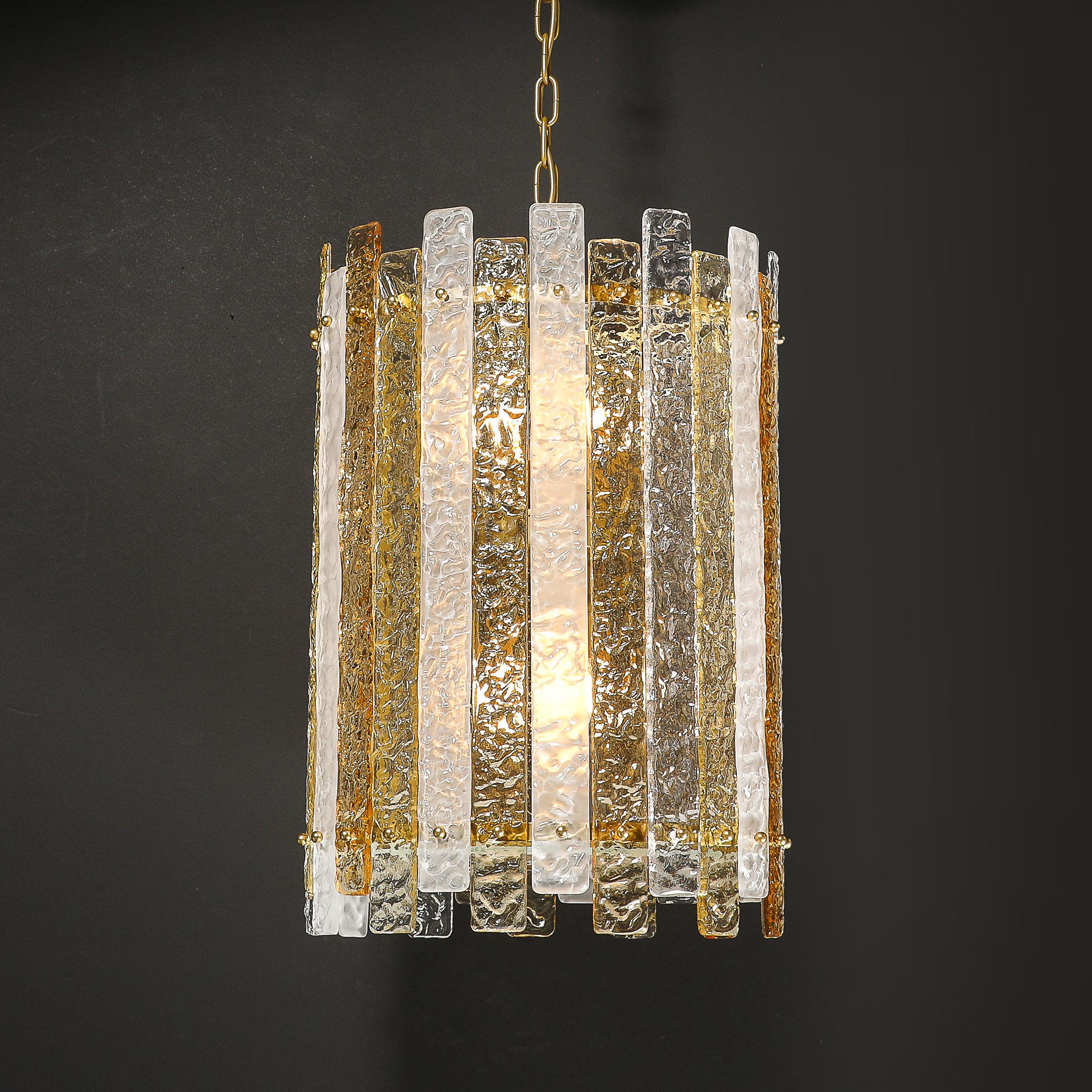 Ce lustre pendentif cylindrique en verre de Murano soufflé à la main dans des teintes givrées, claires et ambrées avec diffuseur et accessoires en laiton provient d'Italie au 21e siècle et constitue un témoignage étonnant de l'art du verre d'art
