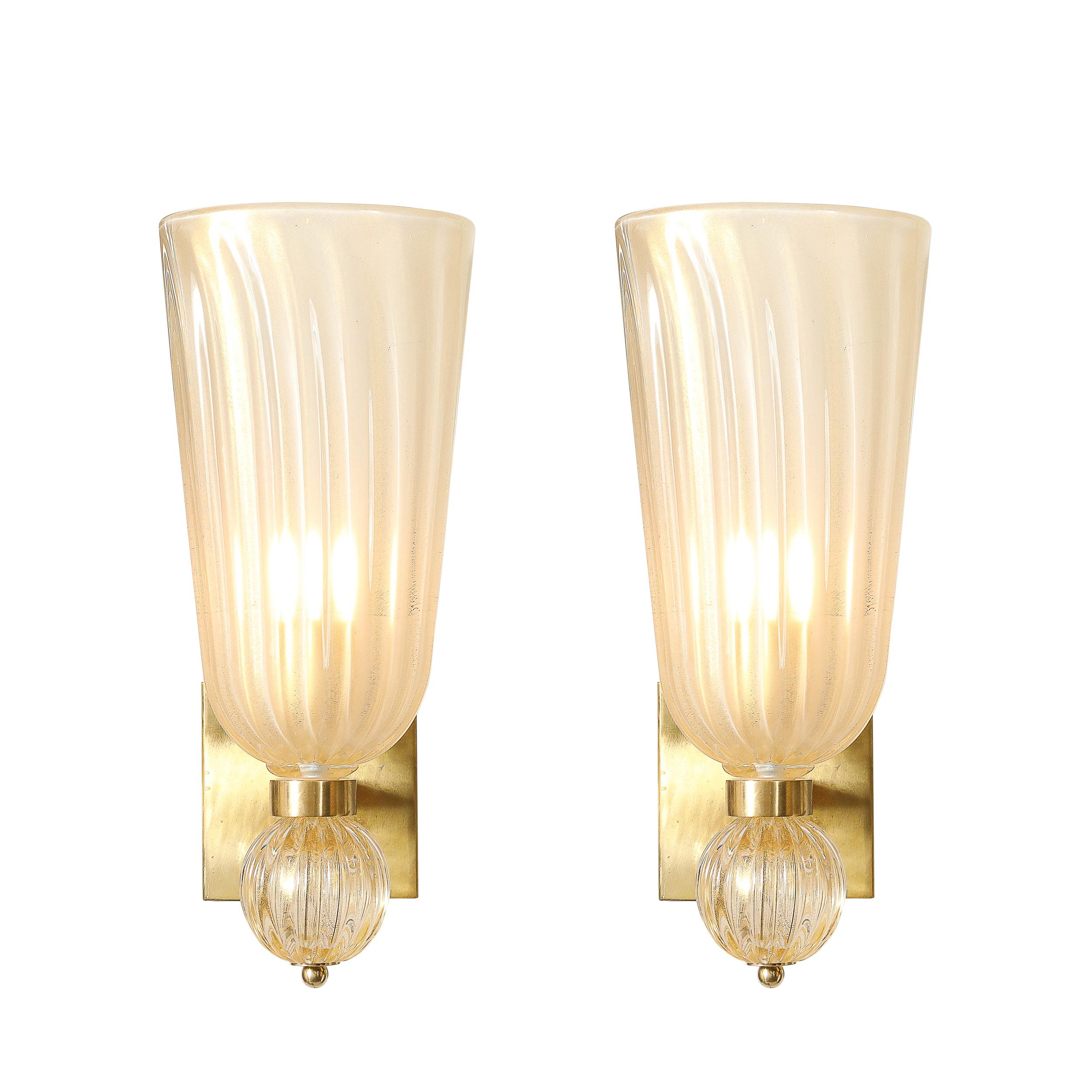 Questa squisita coppia di appliques moderniste esemplifica la maestria dell'arte vetraria di Murano, con vetro scanalato soffiato a mano e arricchito da delicate macchie d'oro a 24 carati. Realizzate in Italia nel XXI secolo, queste applique