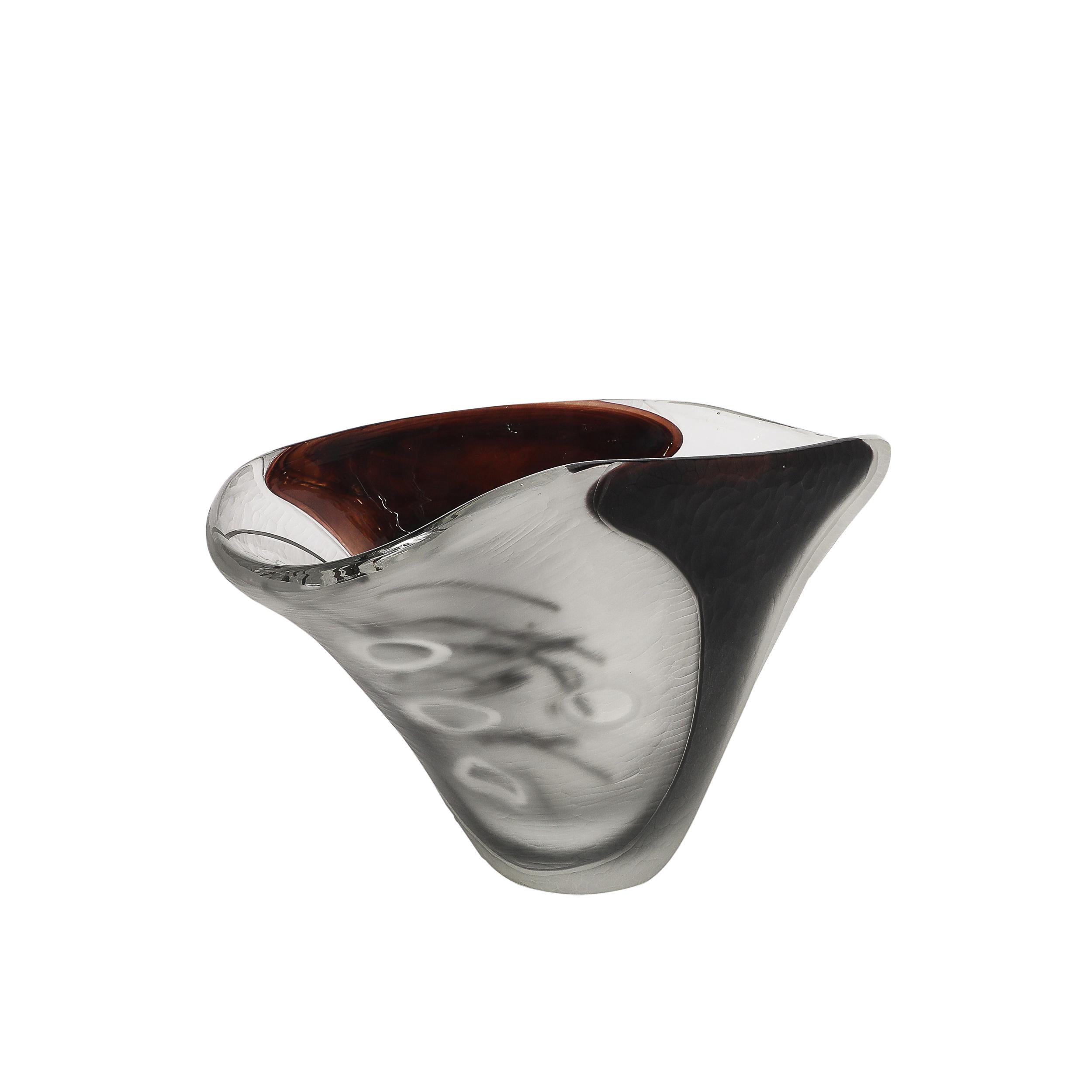 Questo centrotavola modernista in vetro di Murano, realizzato in Italia nel XXI secolo, è una splendida testimonianza dell'arte e dell'innovazione della rinomata tradizione vetraria di Murano. Caratterizzata da una finitura smerigliata a battuto e