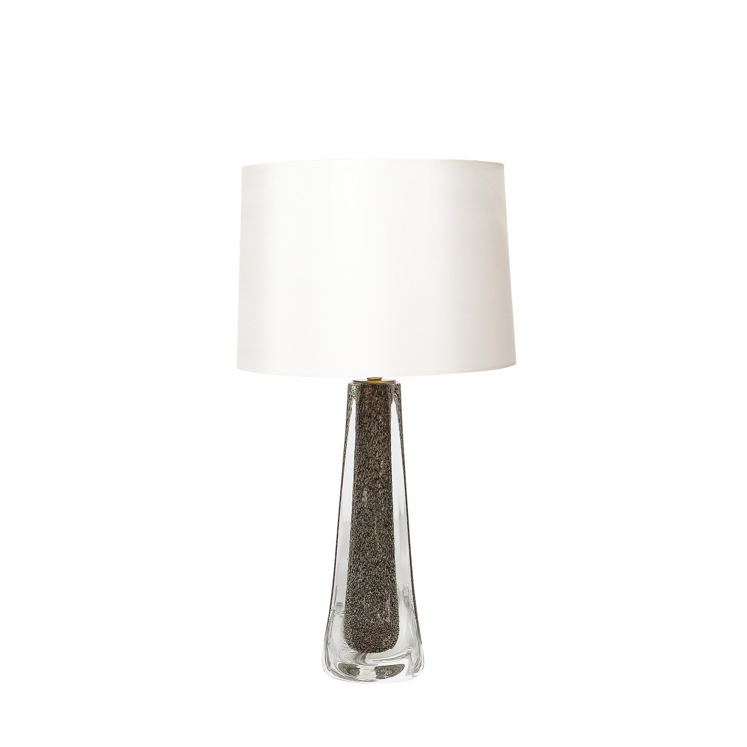 These bold and materially stunning Modernist Hand-Blown Murano Glass Table Lamps W/ Bullicante Detailing in Smoked Bronze & Brass Fittings originate from Italy during the 21st Century. The feature incredible detailing beneath a layer of translucent