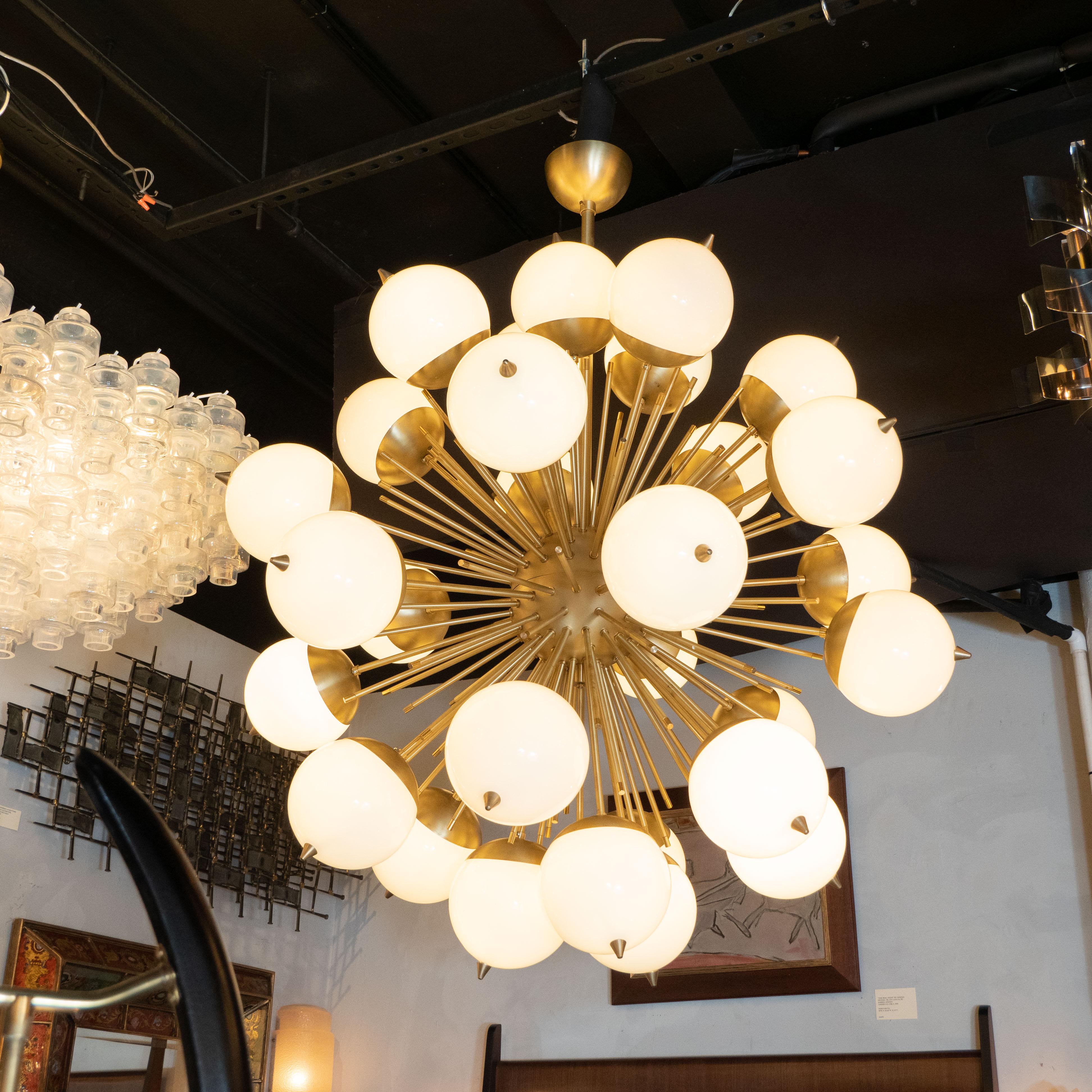 This stunning chandelier was hand blown in Murano, Italy- the island off the coast of Venice renowned for centuries for its superlative glass production. It features an abundance of brushed brass cylindrical rods emanating from a spherical body in