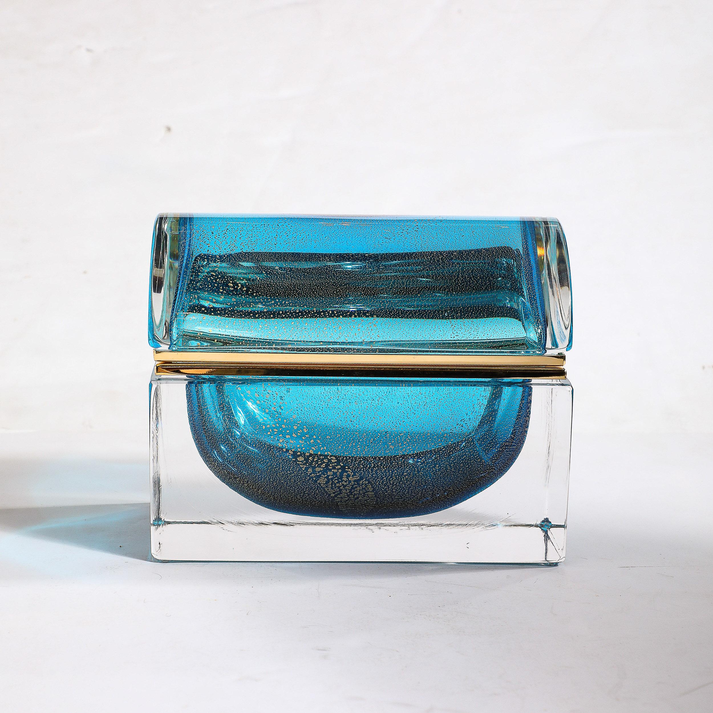 This serenely gorgeous Modernist Hand-Blown Murano Glass Box in Aquamarine W/24 Karat Gold Flecks & Brass Fittings originates from Italy during the 21st Century. Features a rounded top with translucent glass on the outer surface, beneath which is a