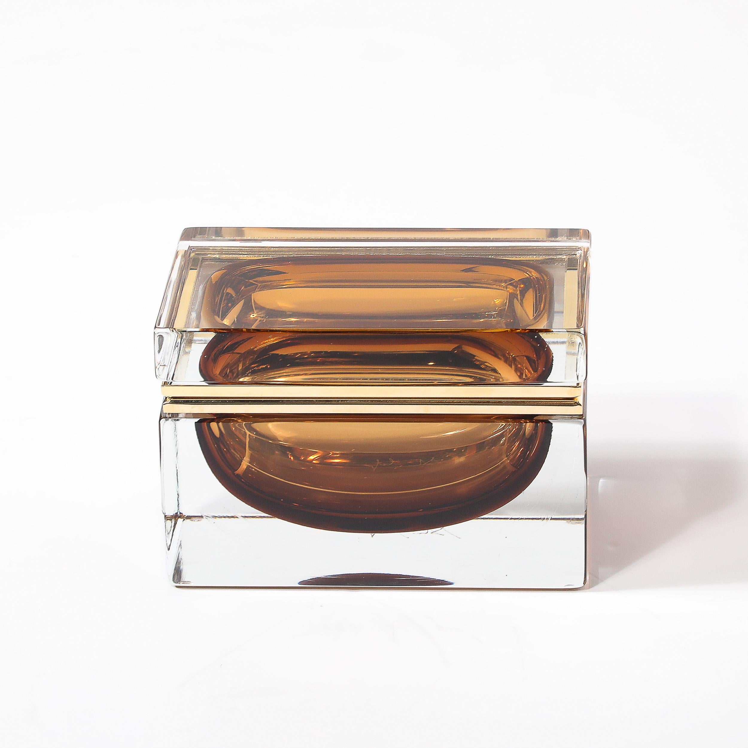 This Modernist Hand-Blown Murano Glass Box in radiant smoked tobacco is a vibrant and elegant accessory, handcrafted in Italy during the 21st century. Meticulously created by Murano artisans, this piece reflects the long-standing Venetian tradition