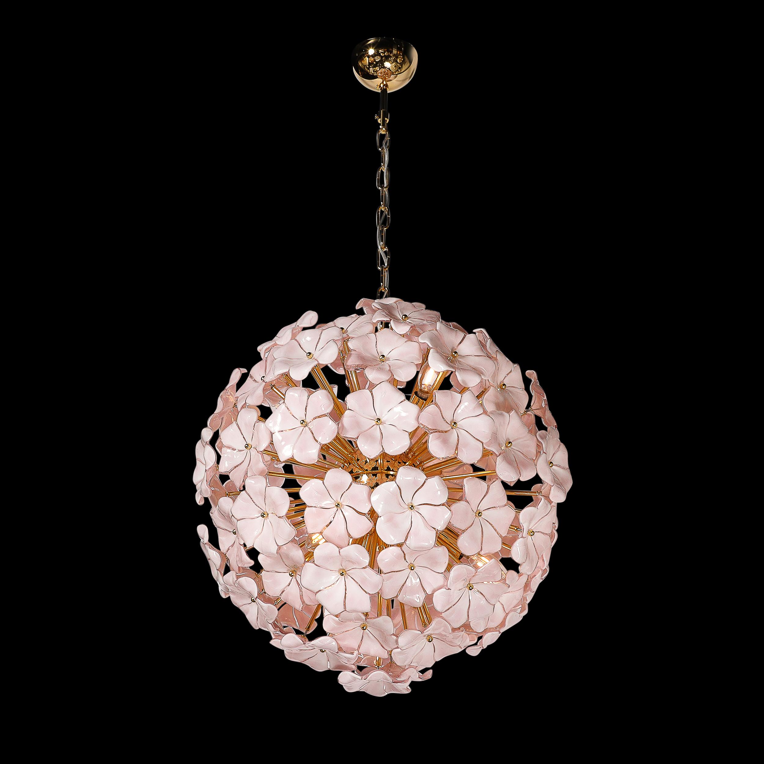 This ornate and alluring Modernist Hand-Blown Murano Glass Sakura Pink Floral Chandelier W/ Brass Fittings originates from Italy during the 21st Century. Composed of a numerous array of hand-blown murano glass floral shades rendered in a beautiful