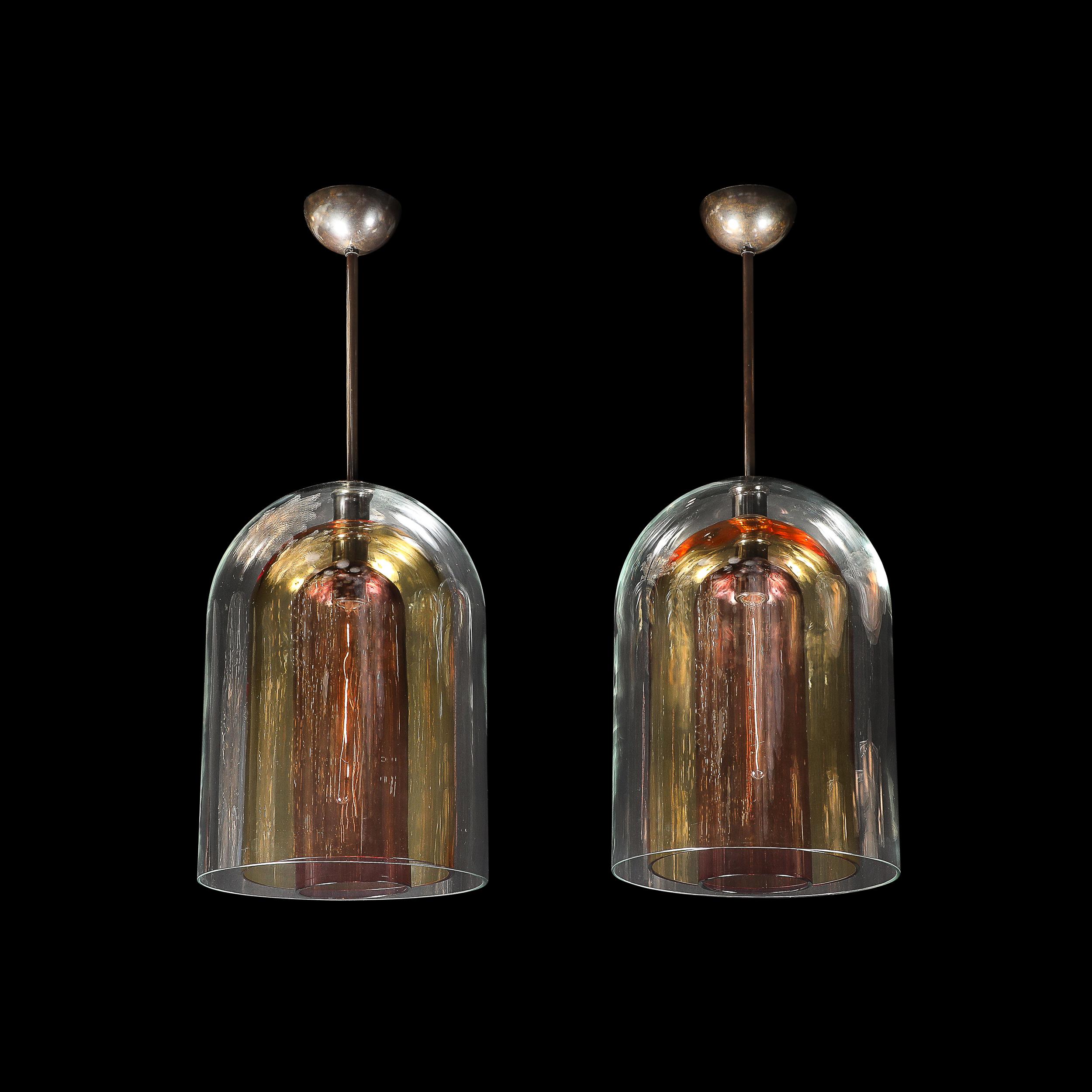 Questa sorprendente coppia di lampadari modernisti mette in mostra l'abilità del vetro di Murano soffiato a mano, con forme a cupola a tre livelli in un accattivante mix di tonalità chiare, ambrate e affumicate. L'armoniosa miscela di colori e
