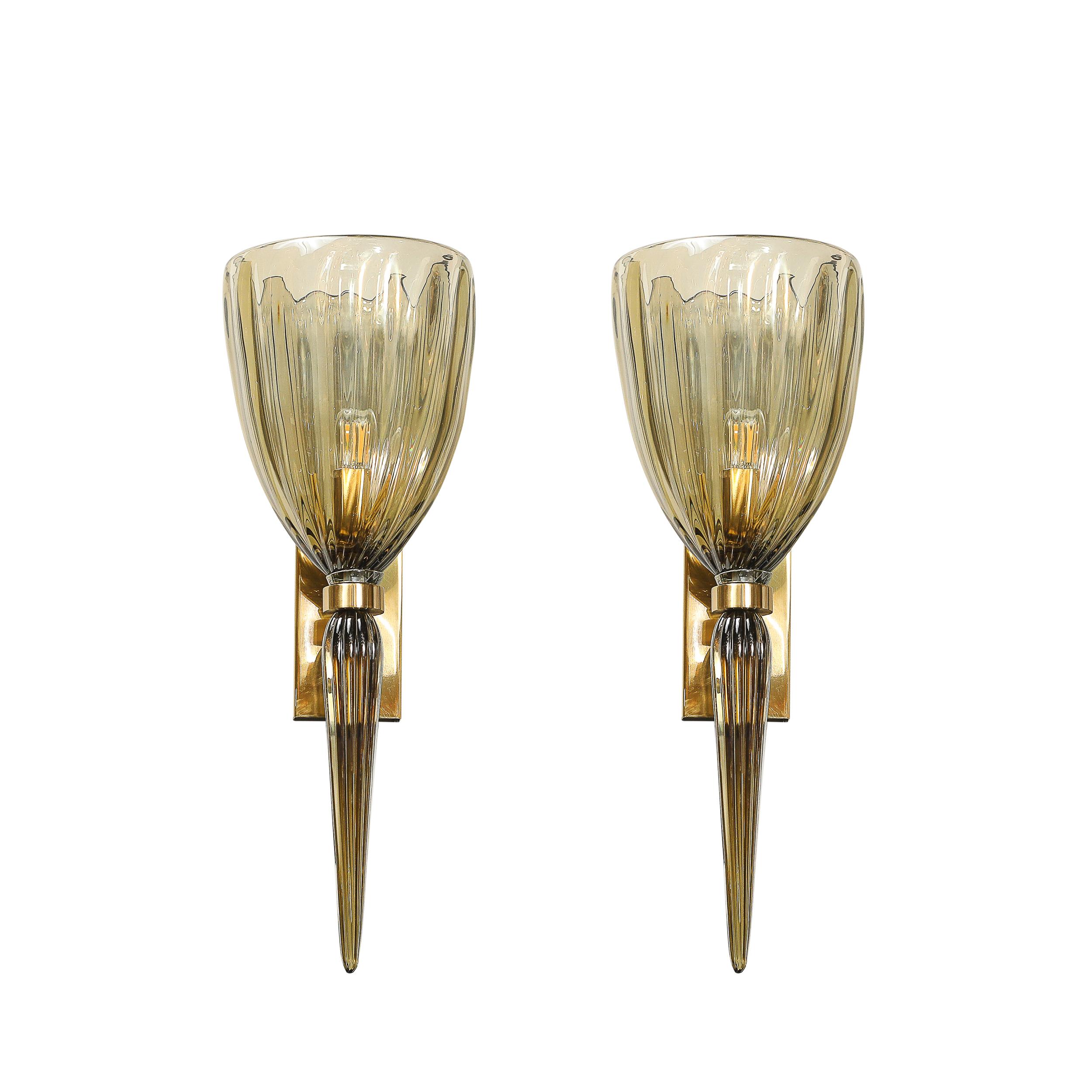 This dazzling pair of modernist Murano glass sconces showcases the finest in Venetian glass artistry, rendered in Italy during the 21st Century. Each sconce is meticulously hand-blown and features a stunning fluted glass design in a captivating