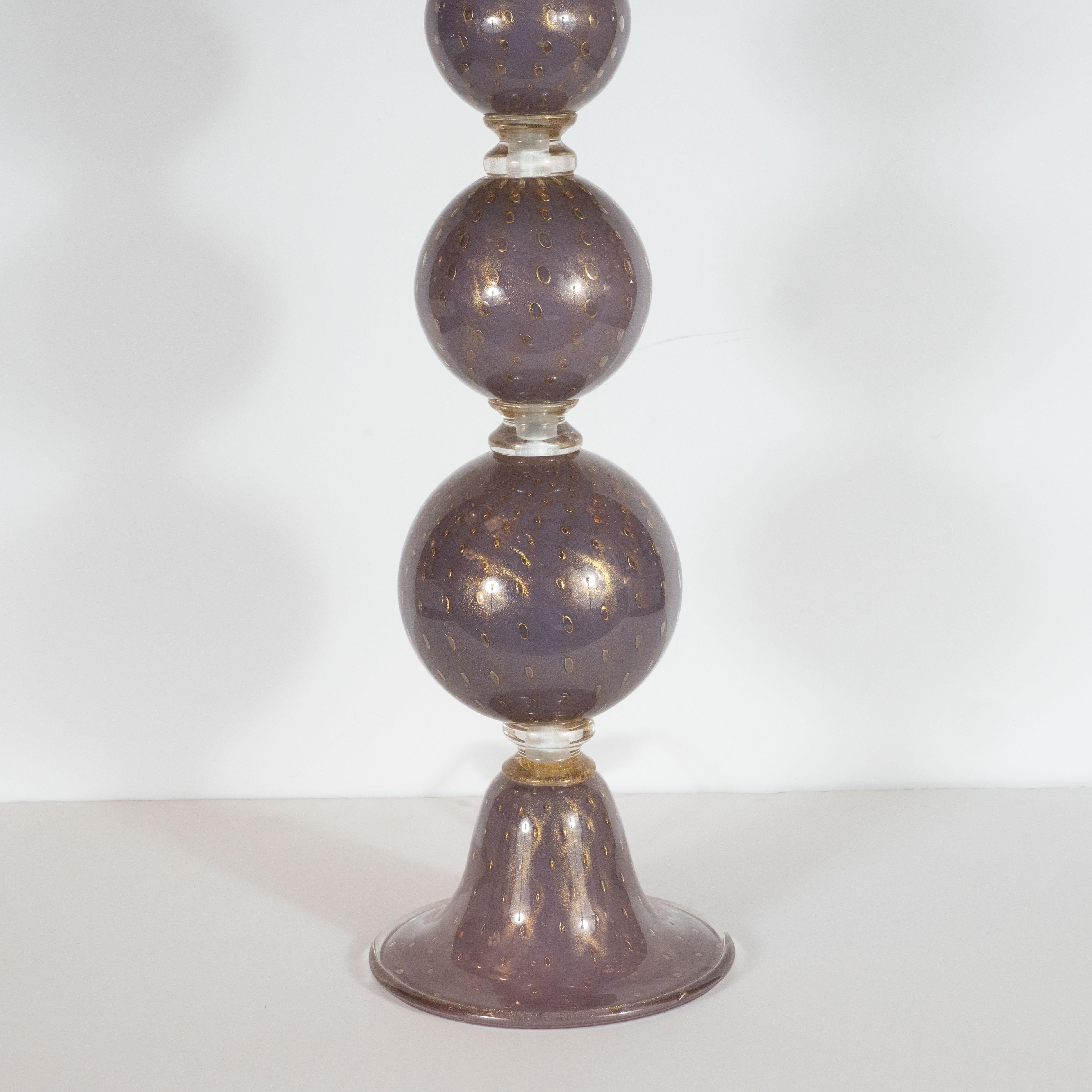 Questa splendida coppia di lampade da tavolo è stata soffiata a mano a Murano, in Italia, l'isola al largo della costa di Venezia rinomata da secoli per la sua superlativa produzione di vetro. Presentano tre forme sferiche che salgono da una base