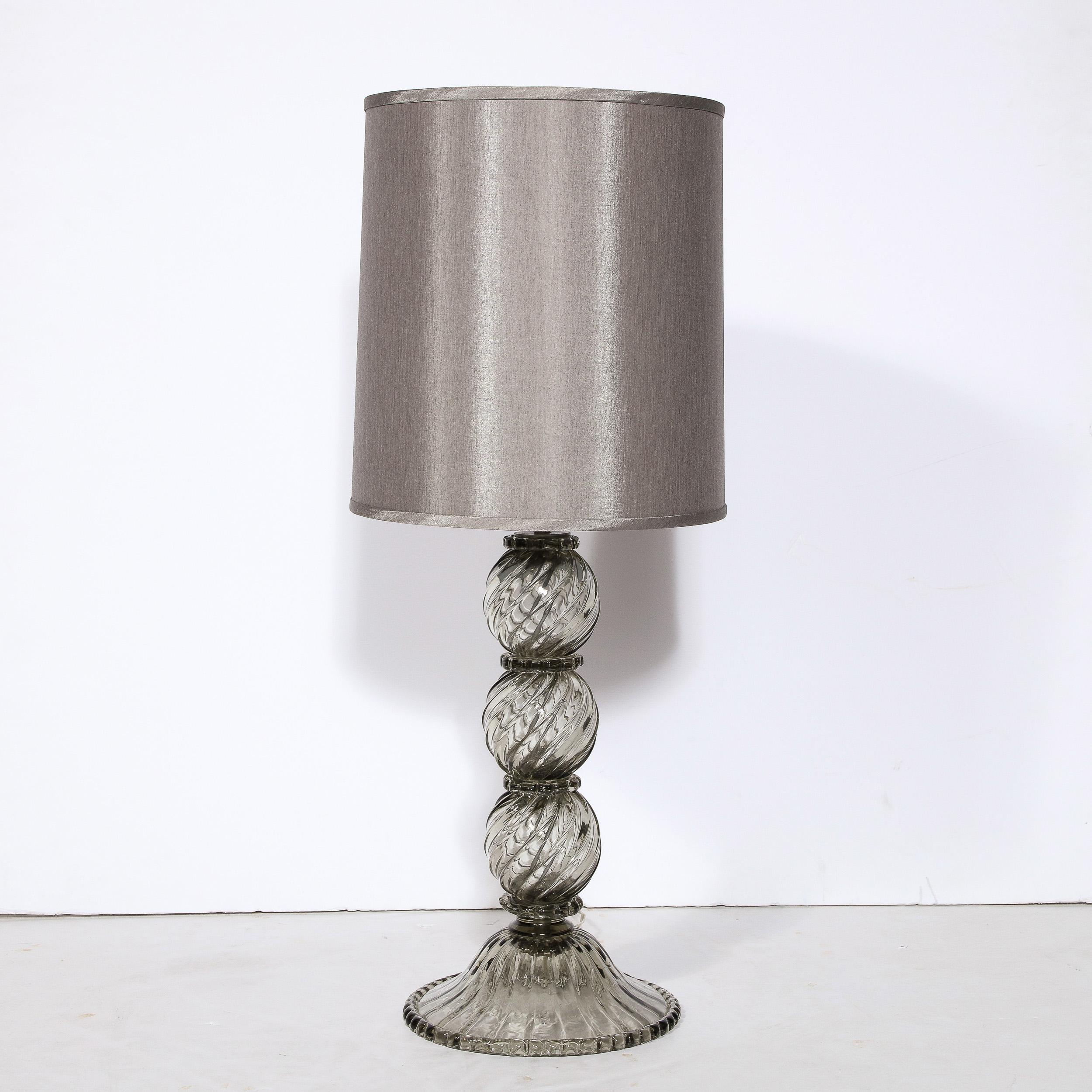 This stunning modernist table lamp was realized in Murano, Italy- the island off the coast of Venice renowned for centuries for its superlative glass production. It features a semi transparent smoked Murano glass with three orbital spheres with a