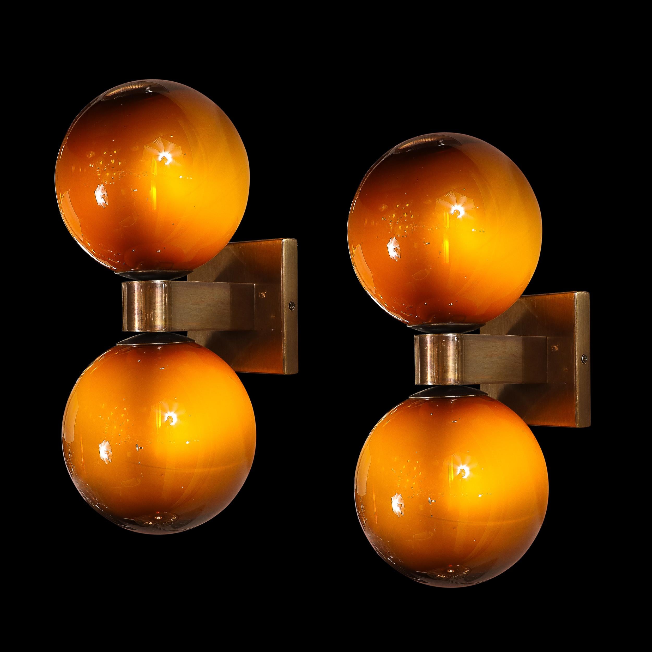 Illuminate your space with this exquisite pair of Modernist Hand-Blown Murano Glass Double Sphere Sconces, offered in a sophisticated Smoked Tortoise hue with bronze fittings. Crafted in Italy in the 21st century, these sconces reflect the renowned
