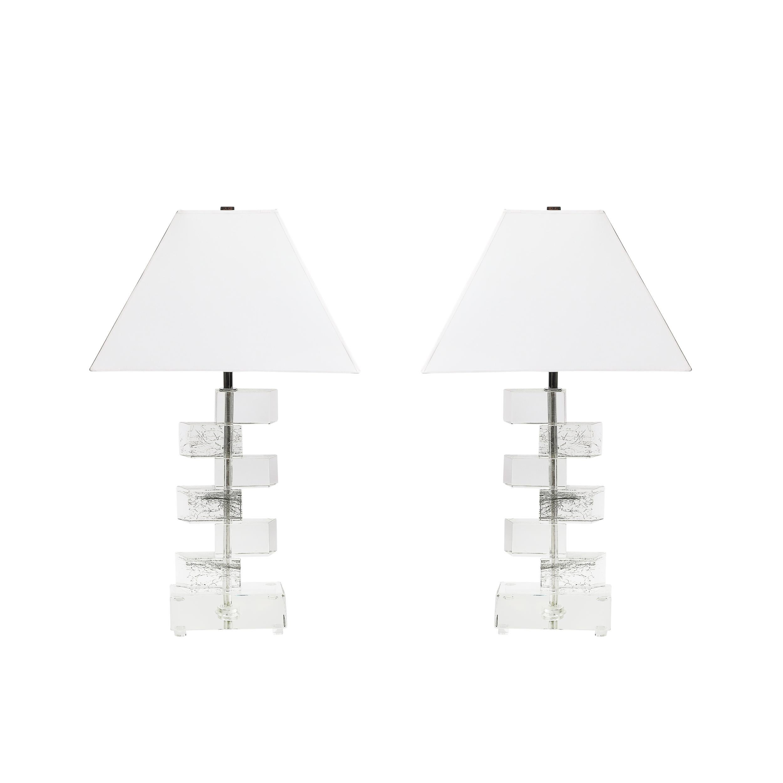 This exquisite pair of modernist Murano glass table lamps, crafted in Italy in the 21st century, exemplifies the enduring artistry and craftsmanship of Murano glassmaking. These lamps feature stunning stacked and faceted trapezoidal glass forms,