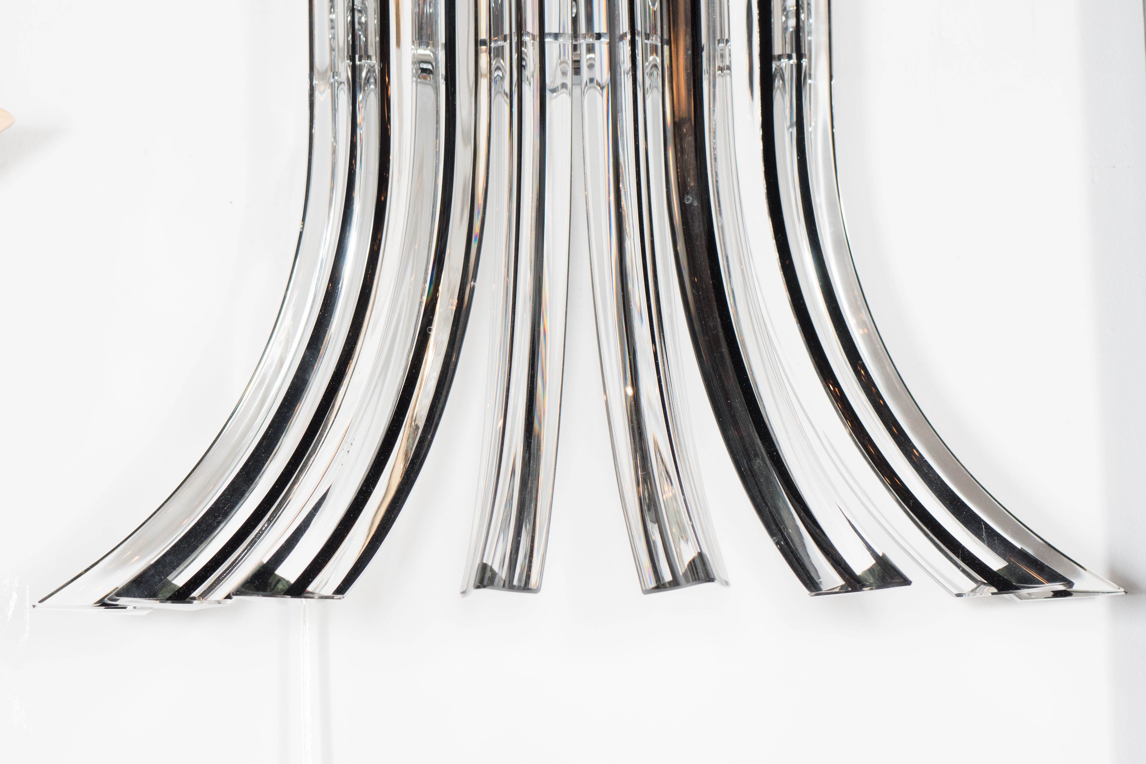 This outstanding pair of Modernist hand blown glass camer sconces were realized in Murano, Italy- the island off the coast of Venice renowned for centuries for its superlative glass production. The sleek pair of sconces are composed of eight curved