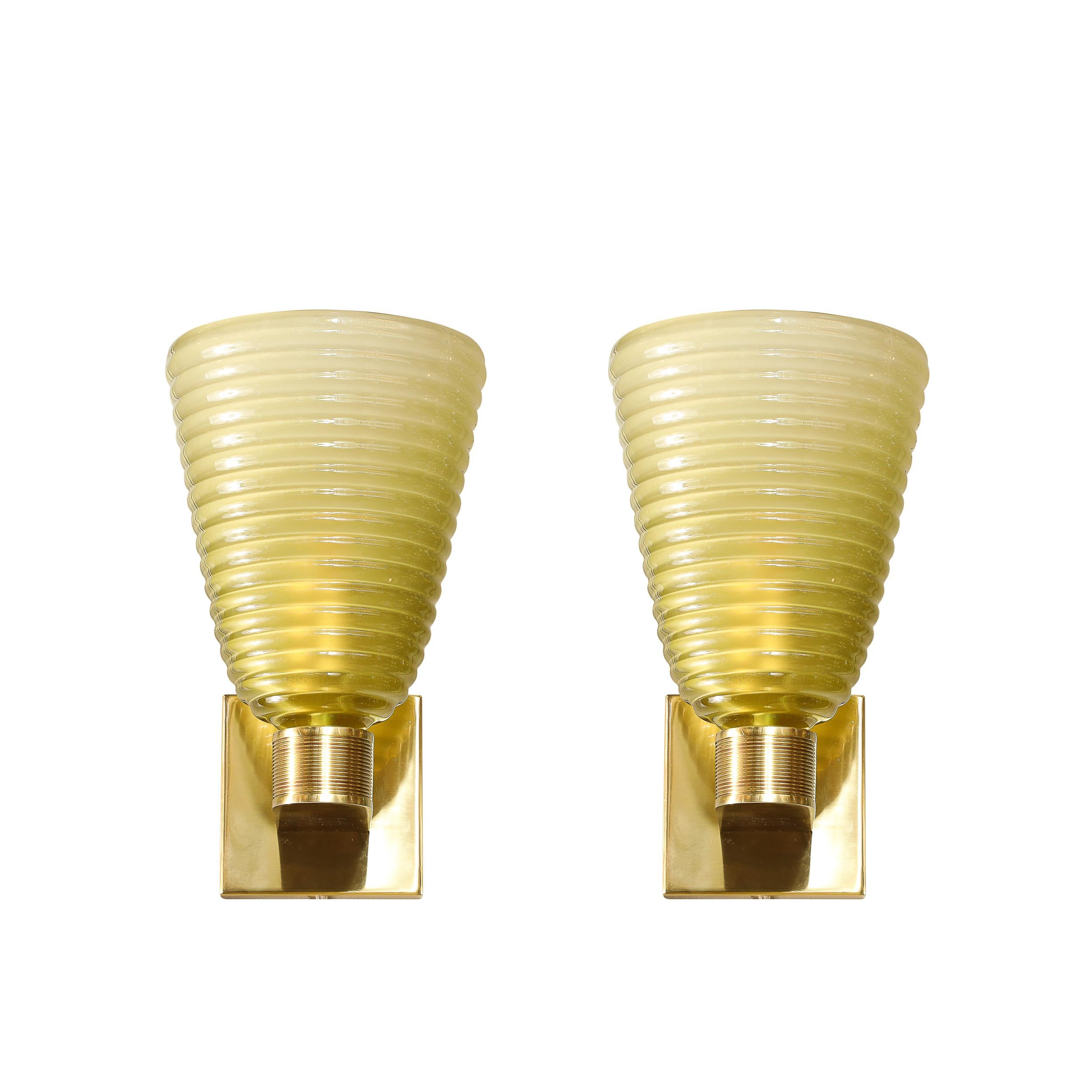 Cette paire exquise d'appliques modernistes en verre de Murano soufflé à la main met en valeur le savoir-faire exceptionnel et le design innovant qui font la renommée de Murano. Créées en Italie au XXIe siècle, ces appliques présentent un verre fumé