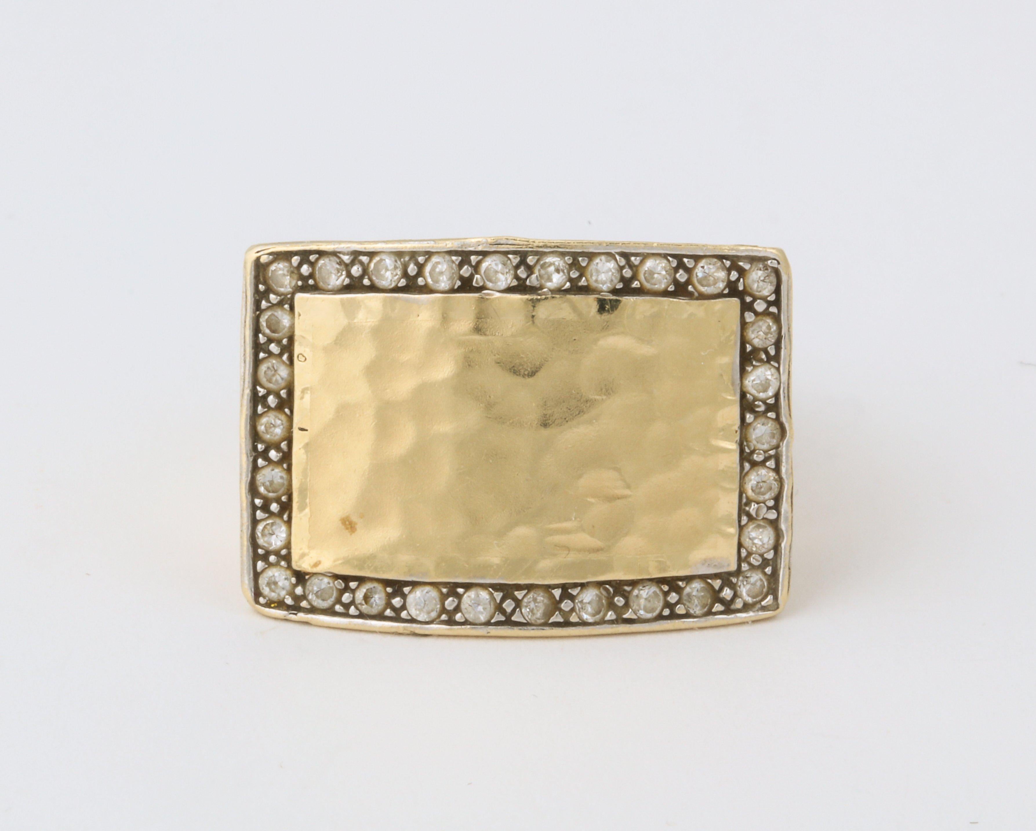 A stunning hand hammered 18K gold ring with diamonds set along the edge.  The rectangular shape makes it very appealing to wear on the middle finger as well as the
ring finger.  