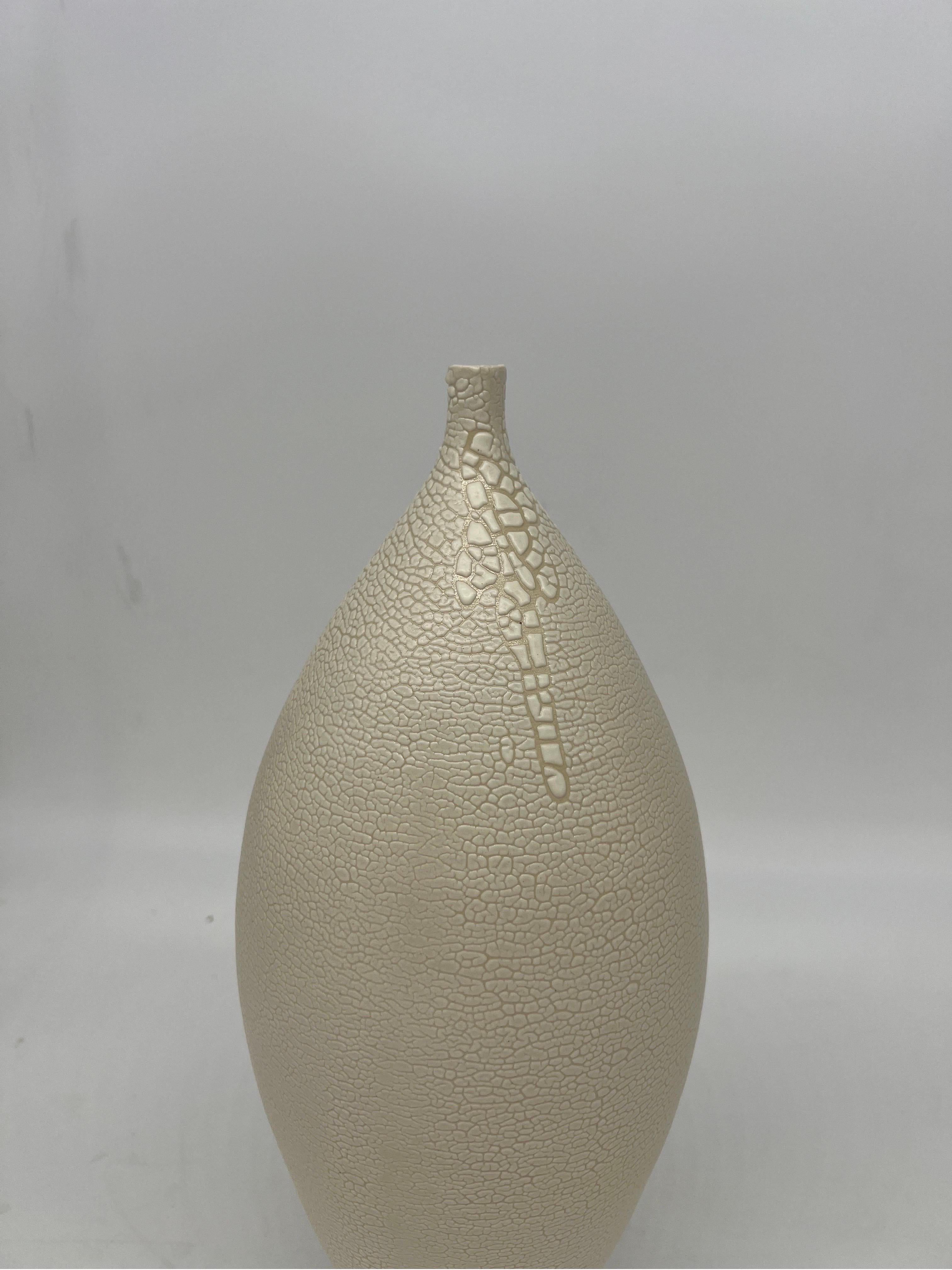 This vase is done by an unidentified artisan, likely late 20th century. Purchased from the estate of an accomplished doctor in Atlanta. The vase has a white body with sculpted work and a lava glaze styling in the Japanese taste. 