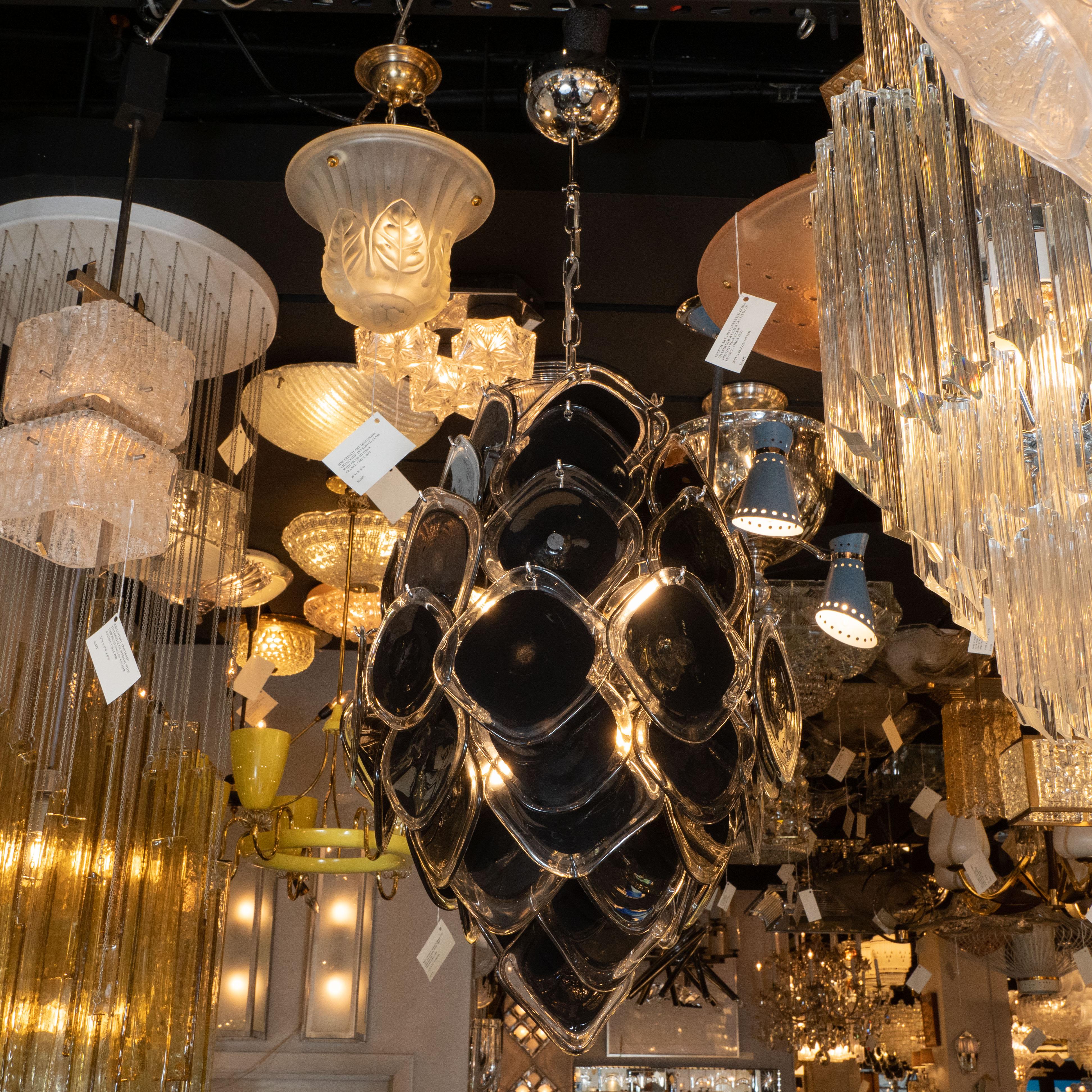 This stunning chandelier was hand blown in Murano, Italy- the island off the coast of Venice renowned for centuries for its superlative glass production. It features a cylindrical form that tapers at each end consisting of an abundance of hand blown