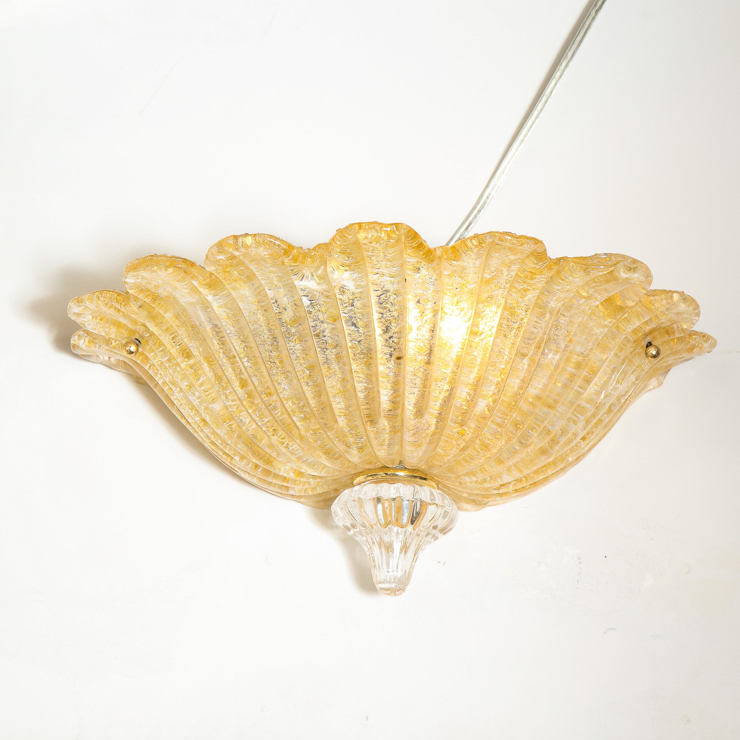 This elegant modernist wall sconce was realized in Murano, Italy- the island off the coast of Venice renowned for centuries for its superlative glass production. It features a textural billowing Murano glass body replete with an abundance of 24kt