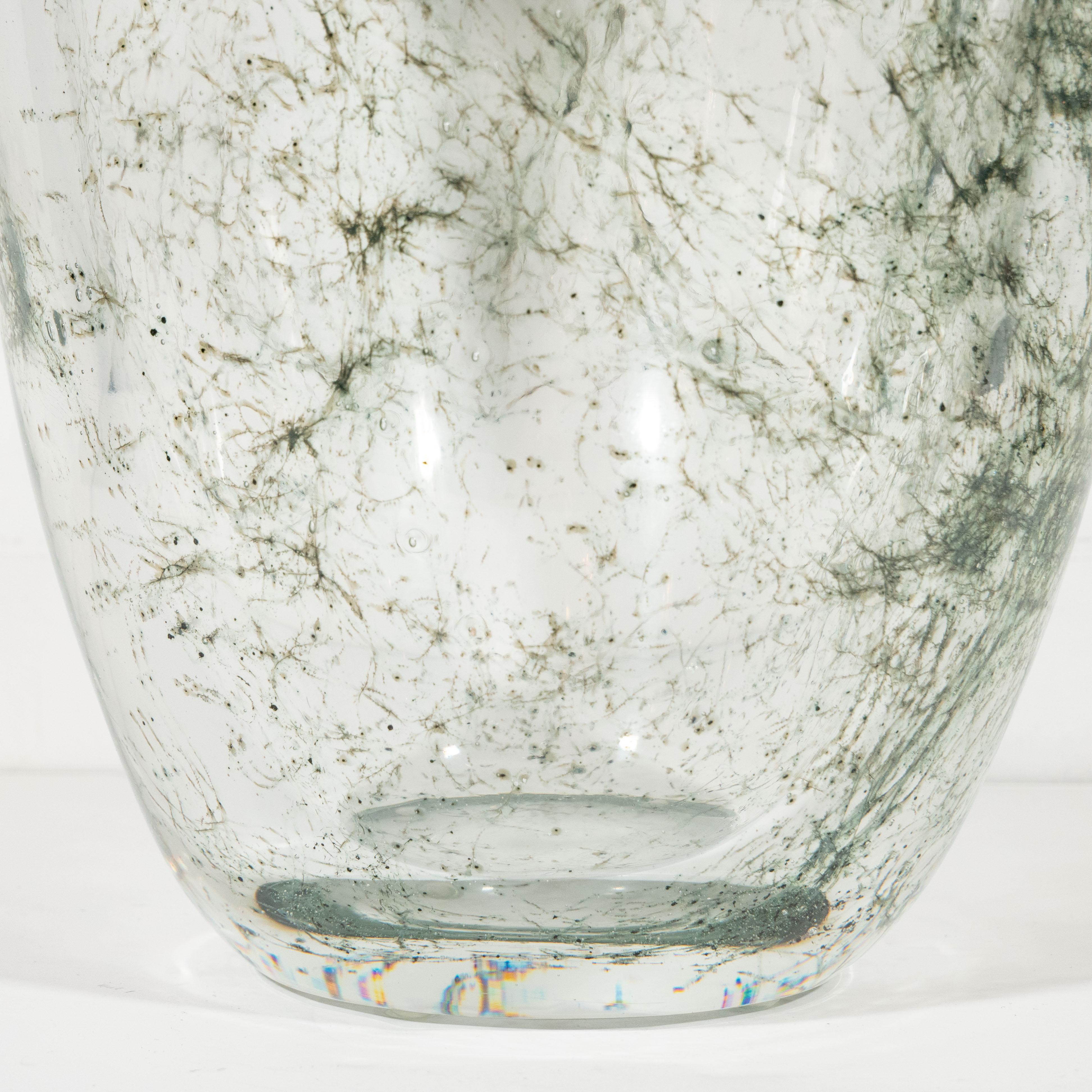 This sophisticated glass vase was handblown in Murano Italy- the island off the coast of Venice renowned for centuries for its superlative glass production. It features a translucent conical body with an abundance of web-like constellations of