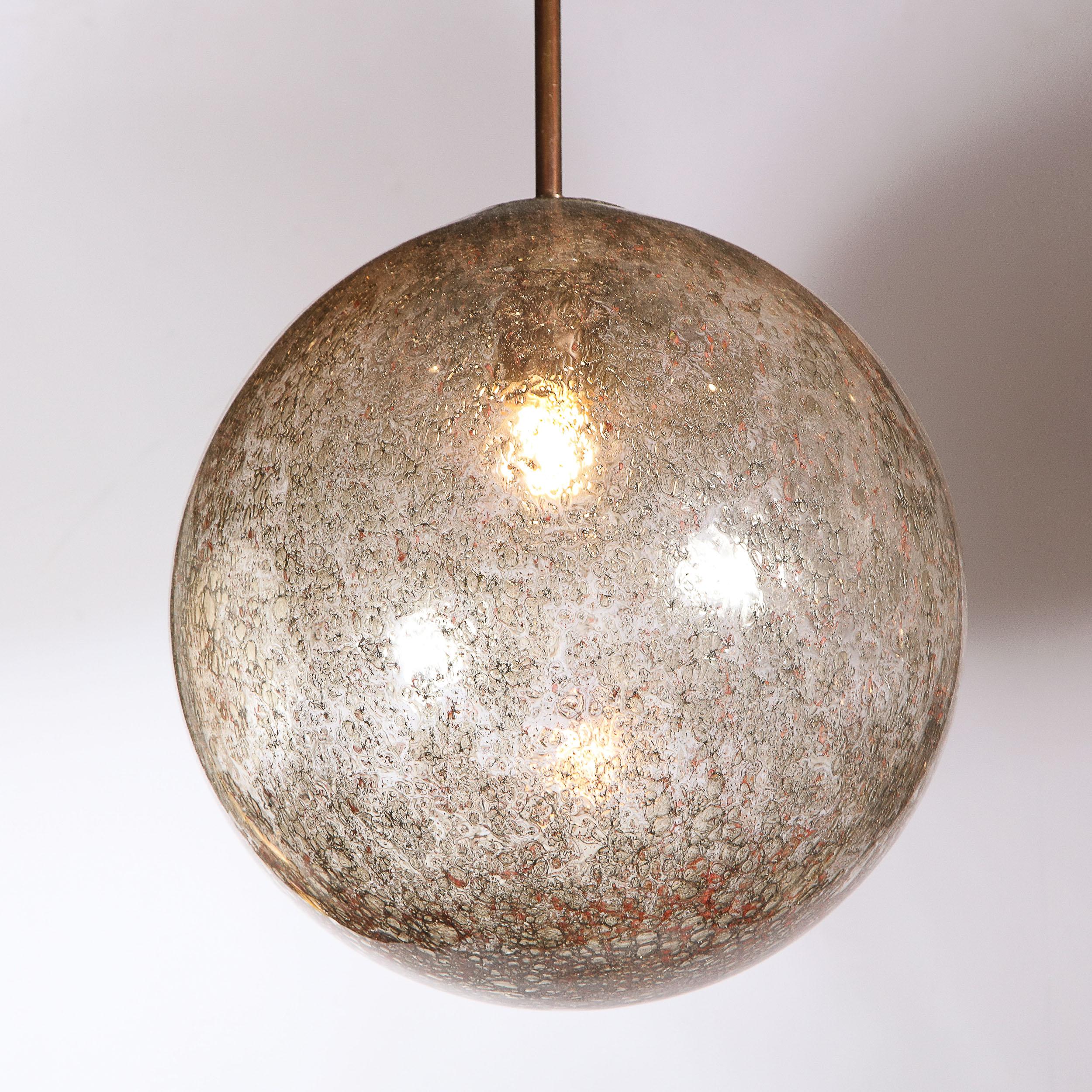 This stunning modernist pendant was realized in Murano, Italy - the island off the coast of Venice renowned for centuries for its superlative glass production. It features a spherical bodie in translucent Murano glass with a wealth of organic smoked