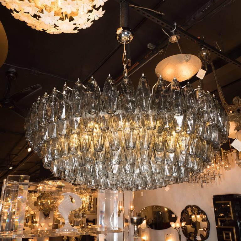 This impressive Murano glass chandelier features a constellation of handblown Murano glass polyhedral glass shades in a smoked pewter grey hue. Each shade has been hand blown and individually hung from its frame. Additionally, the profile of the