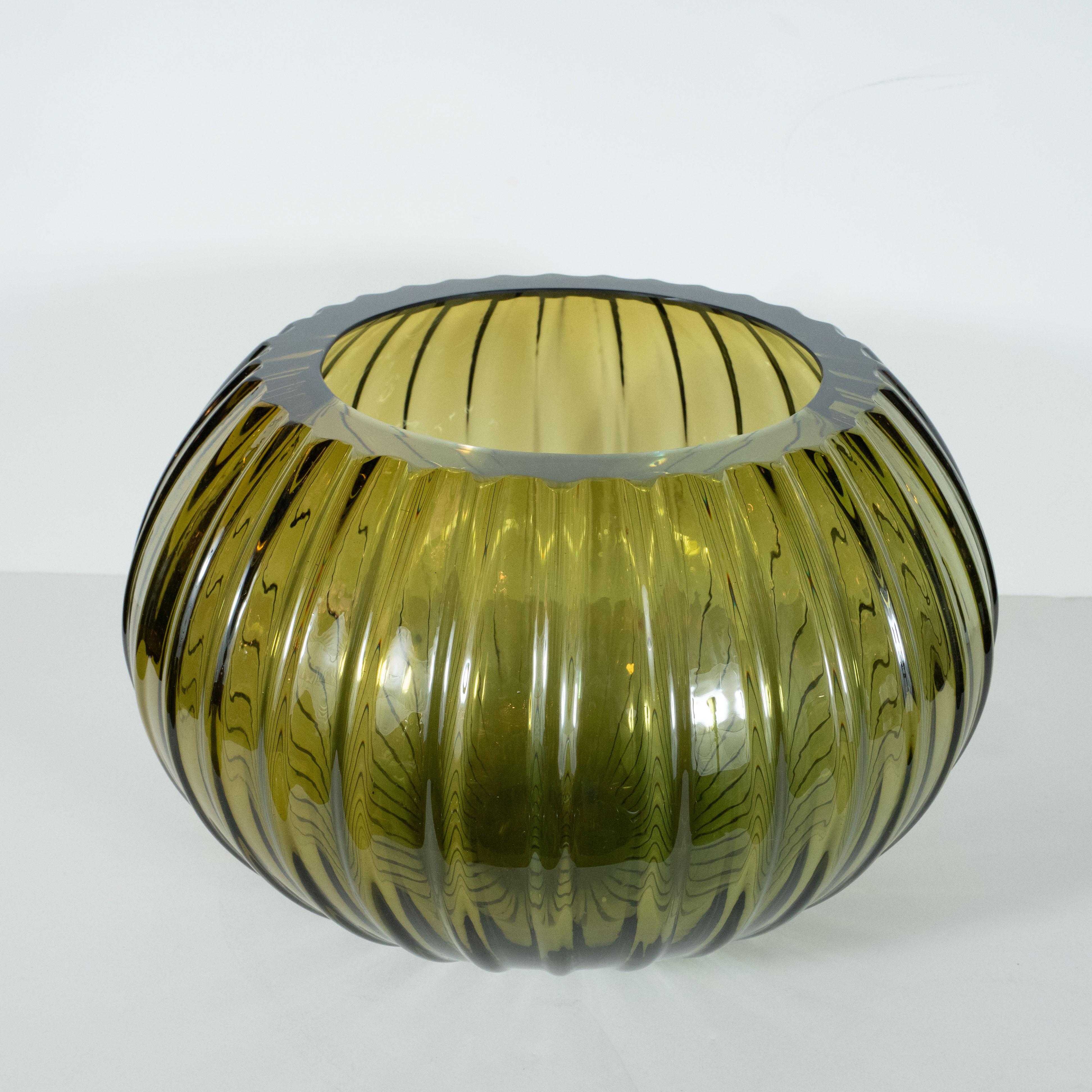 This stunning modernist decorative bowl was hand blown in Murano, Italy- the island off the coast of Venice renowned for centuries for its superlative glass production. It features a subtly ribbed body that expands to its equatorial centre before