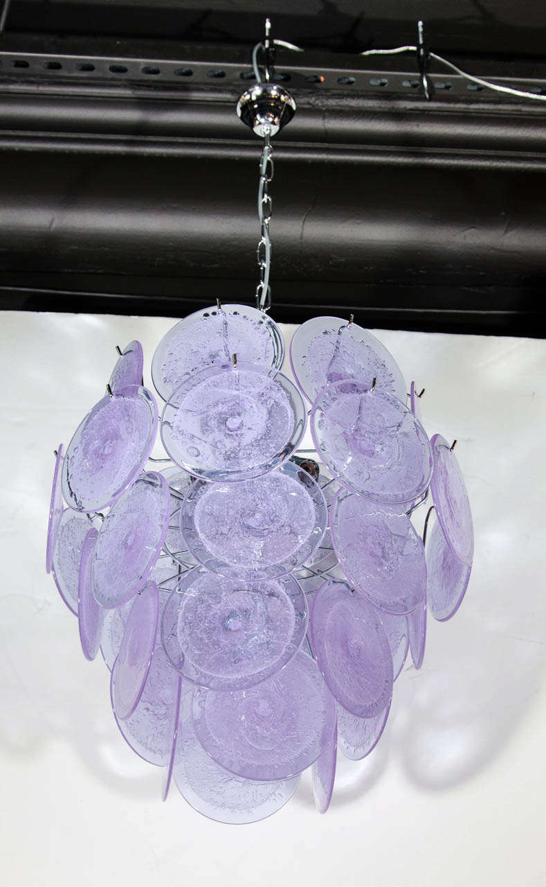 This chandelier, realized in the manner of Vistosi, consists of 36 handmade Murano translucent glass large discs, in a lavender hue, suspended from a polished nickel frame. Created in the same manner since the 1960s by artisans in Murano, Italy,