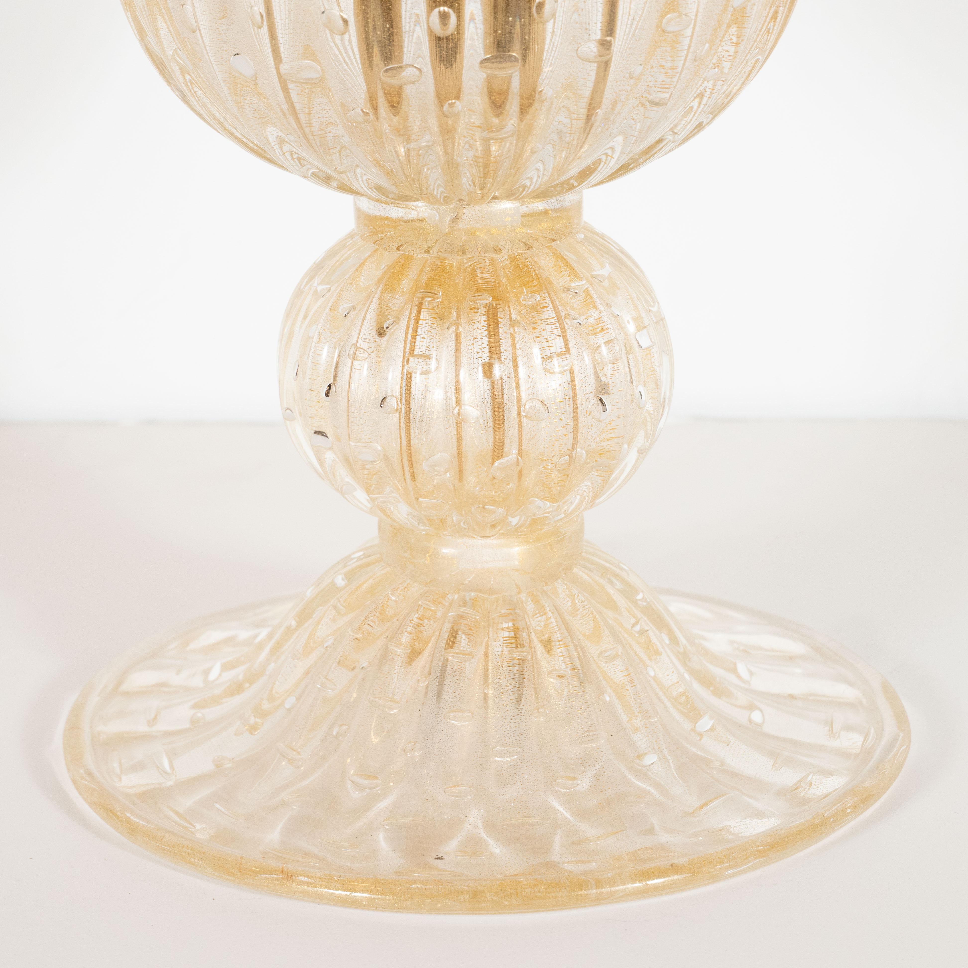 This stunning pair of uplights were handblown in Murano, Italy- the island off the coast of Venice renowned for centuries for its superlative glass production. They feature billowing urn form shades and a subtly domed base topped with an orbital