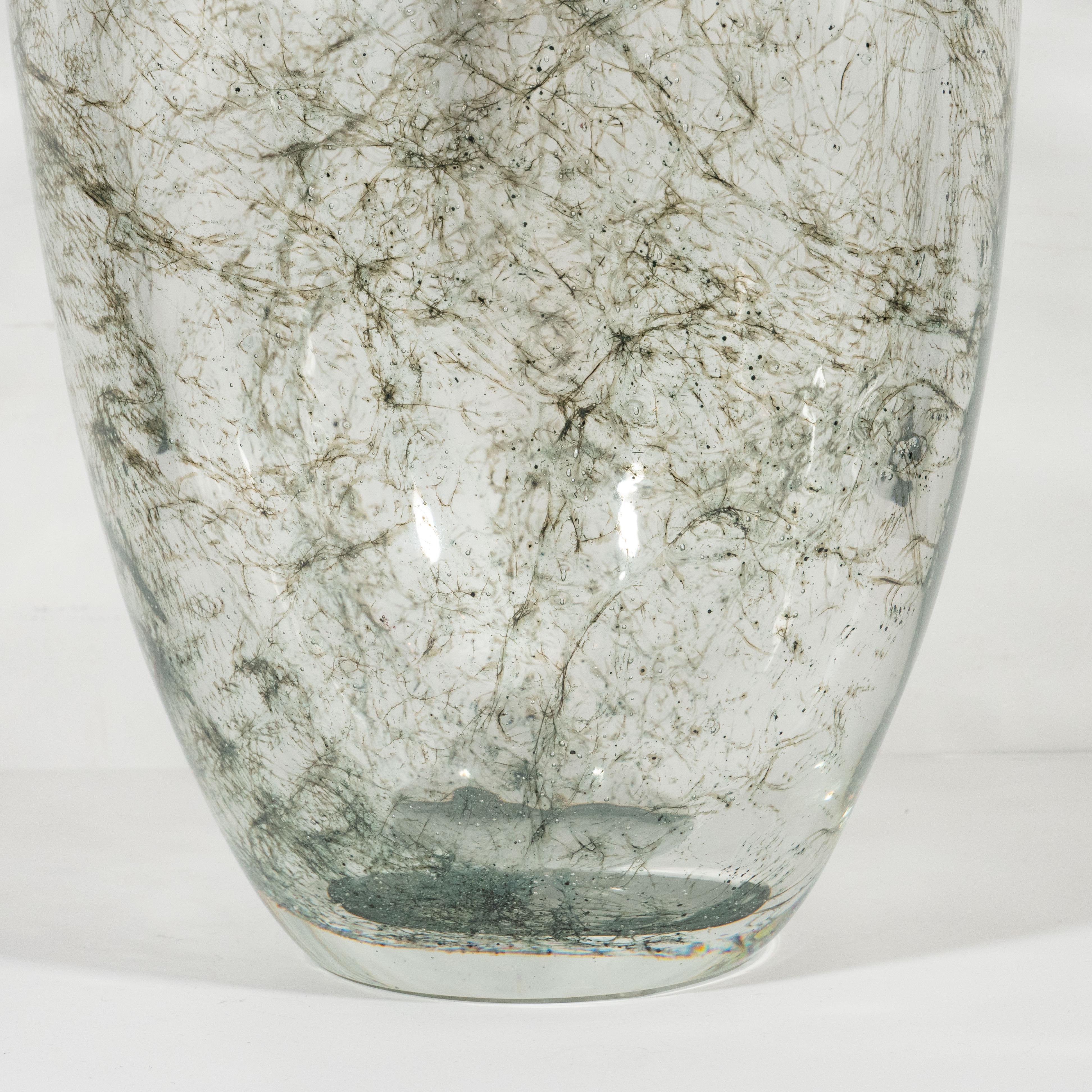 This sophisticated glass vase was handblown in Murano Italy- the island off the coast of Venice renowned for centuries for its superlative glass production. It features a translucent conical body with an abundance of web-like constellations of