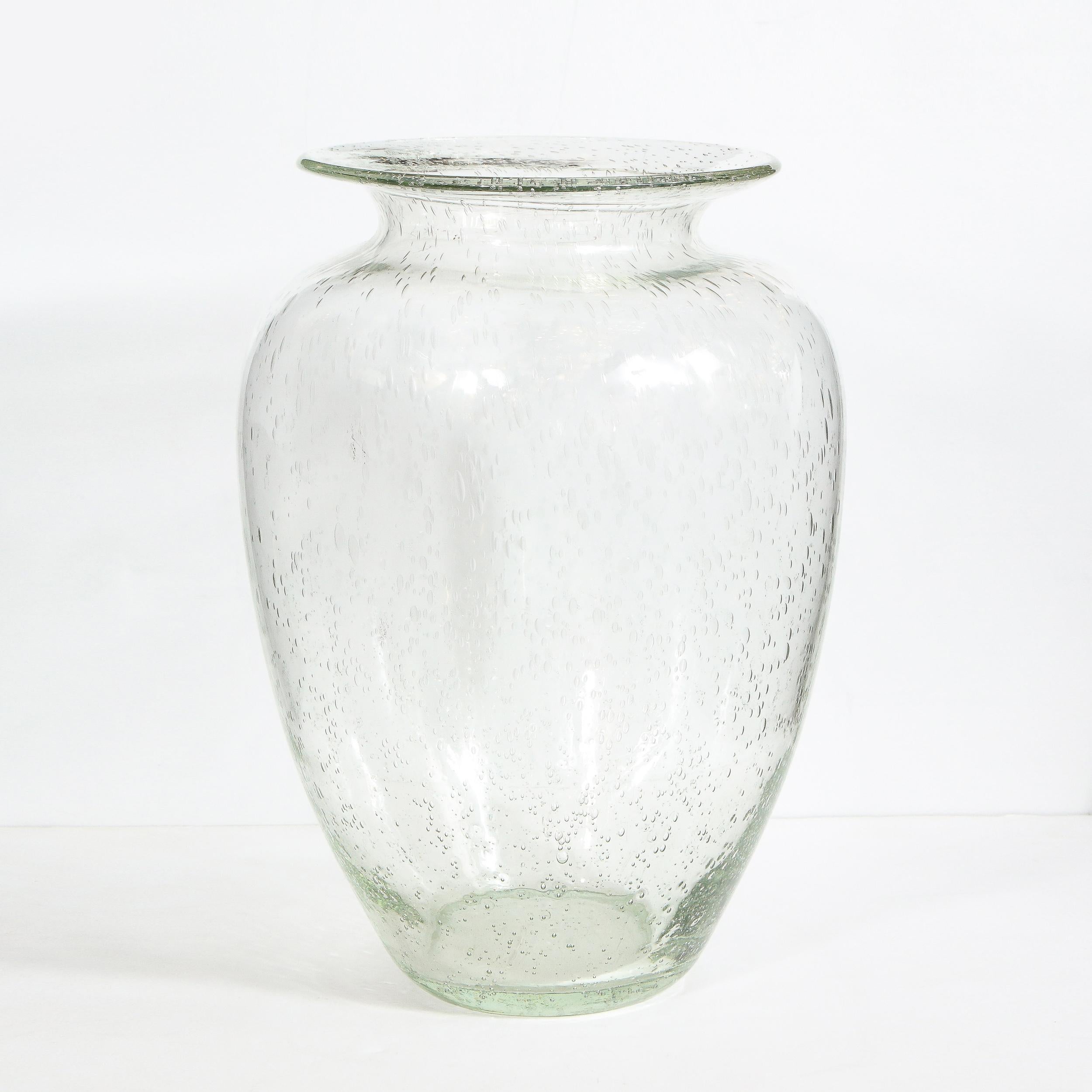 This beautiful modernist vase was hand blown in Murano, Italy- the island off the coast of Venice renowned for centuries for its superlative glass production. It offers a conical body that tapers to each end and flares out at the mouth- all realized