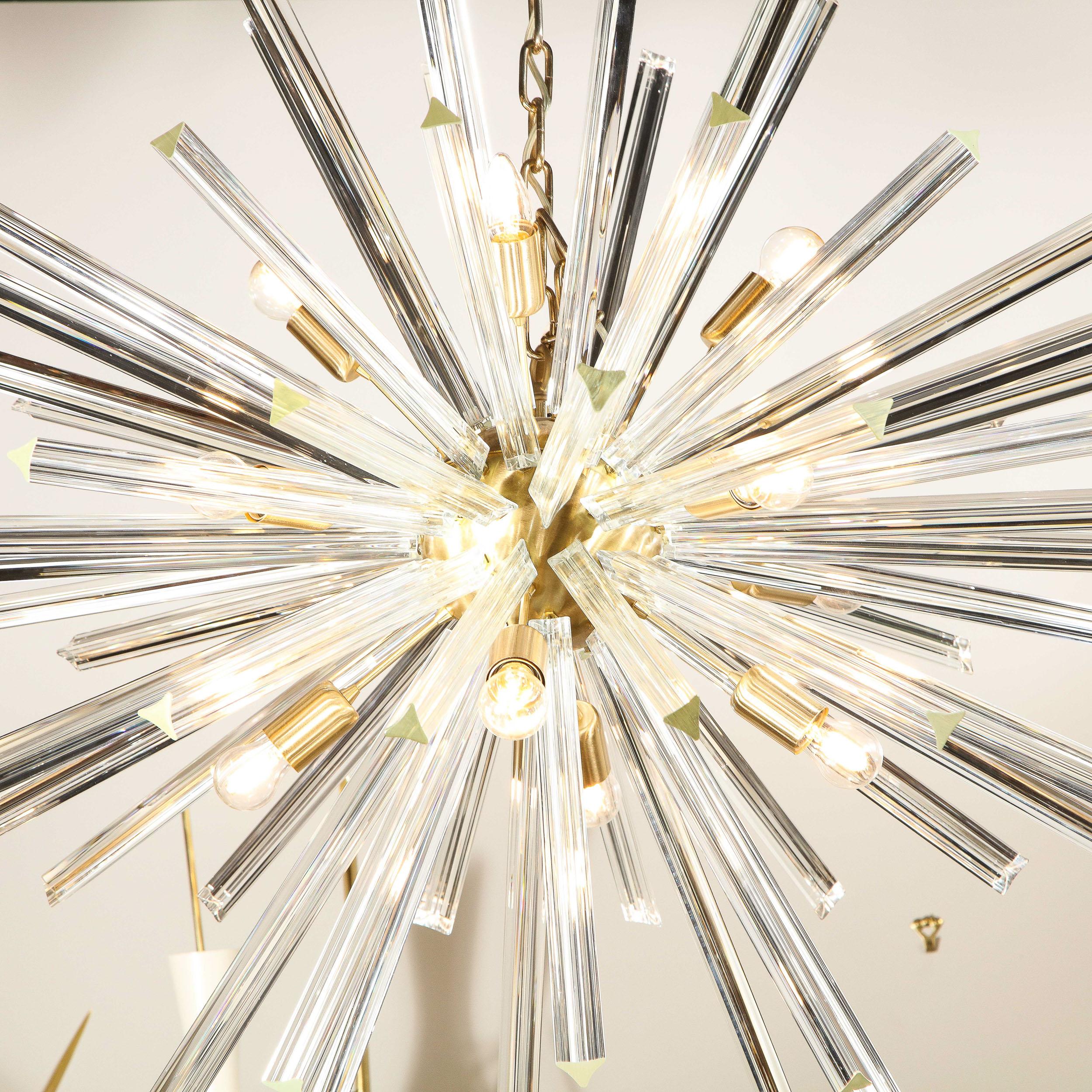 This elegant and graphic Sputnik chandelier was hand blown in Murano, Italy- the island off the coast of Venice renowned for centuries for its superlative glass production. It features a spherical central orb in brushed brass with an abundance of