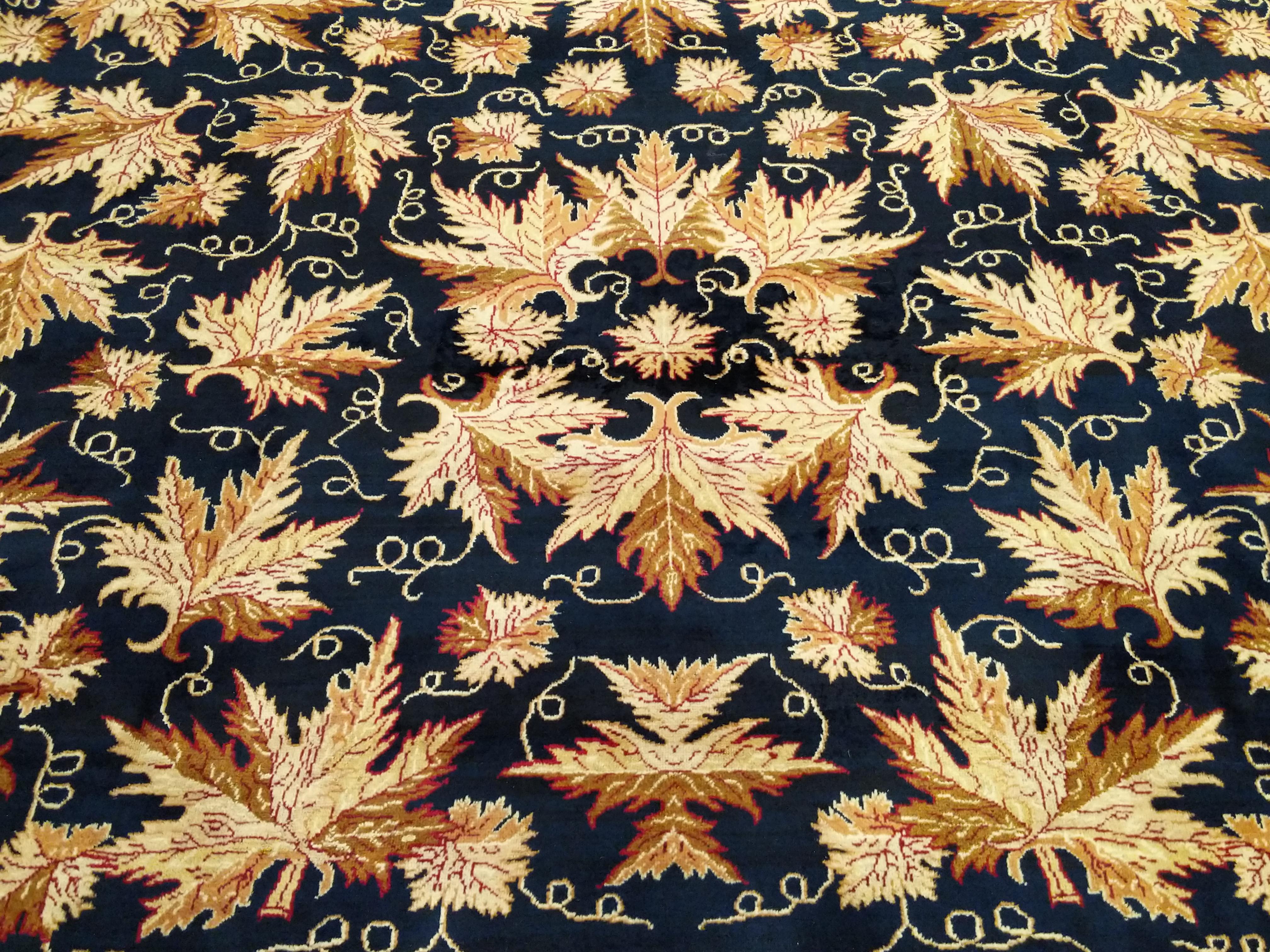A highly unusual rug distinguished by a repeat pattern of realistically drawn oak leafs on a midnight blue background. Finely knotted for this type, it is quite subdued with its neutral palette of naturally contrasting leafs. A very durable carpet