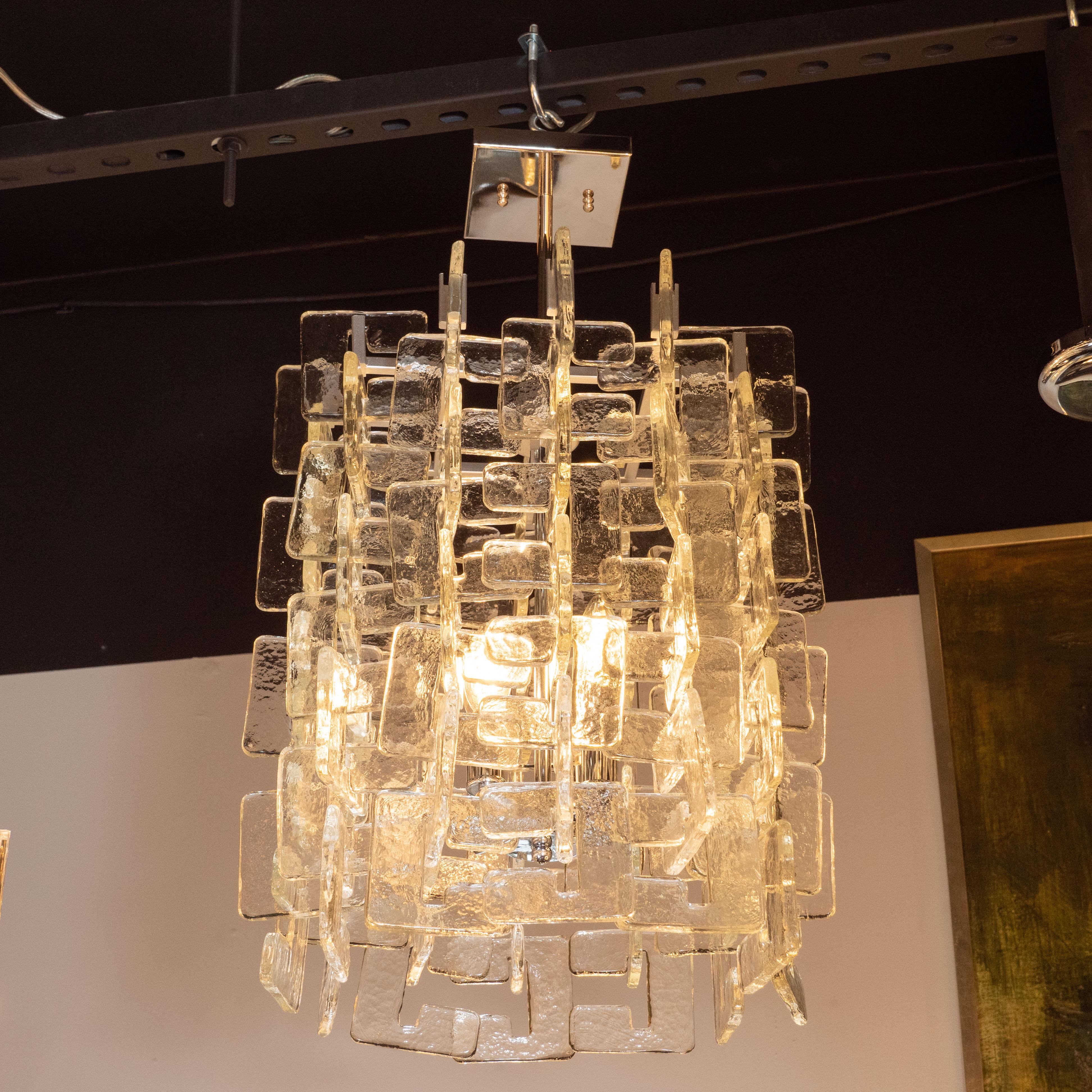 This gorgeous modernist chandelier was realized in Murano, Italy- the island off the coast of Venice renowned for centuries for its superlative glass production. It features an abundance of translucent c-shaped shades that elegantly interlock