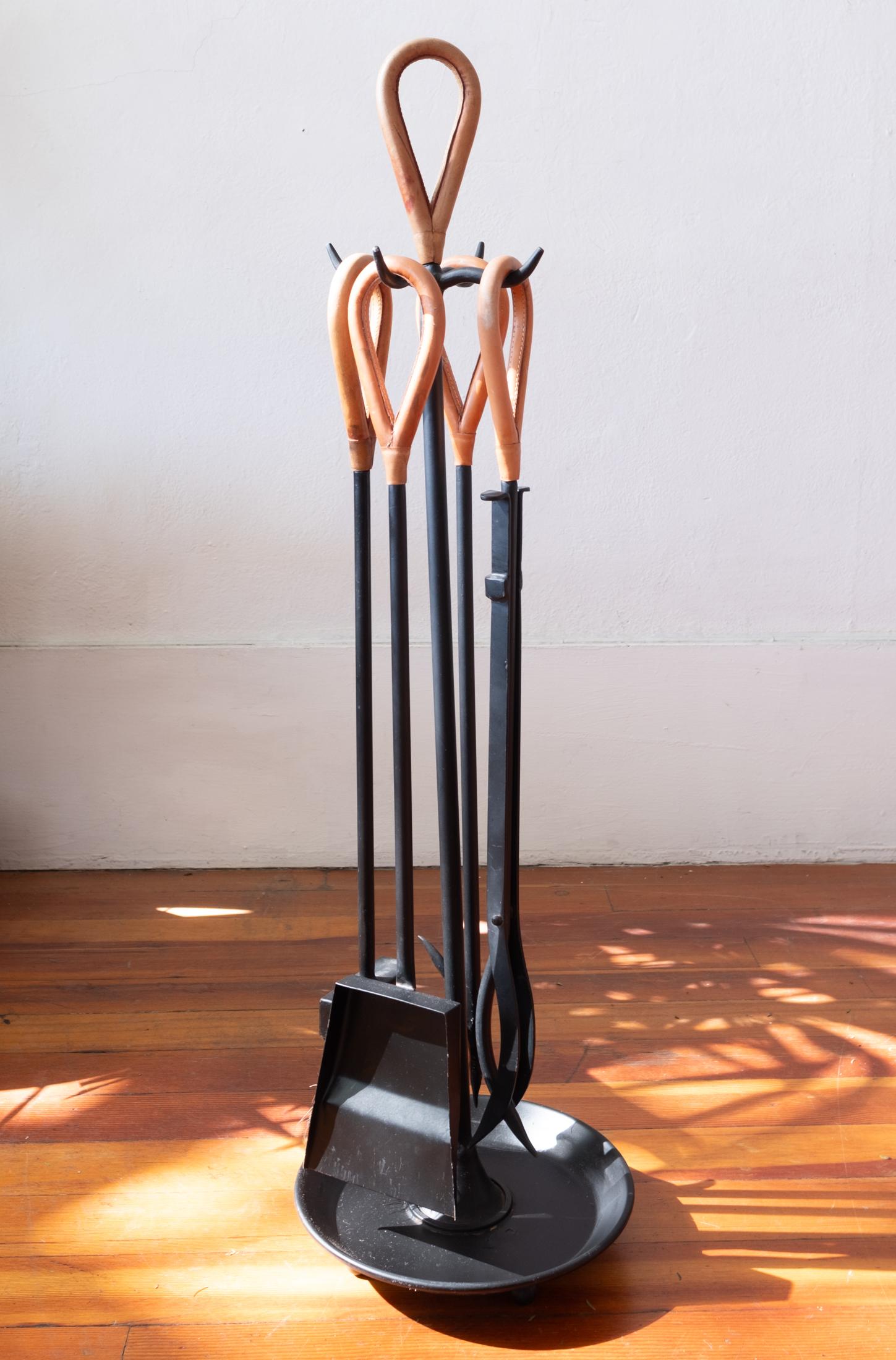 A nice modernist fire place tool set with leather wrapped handles.