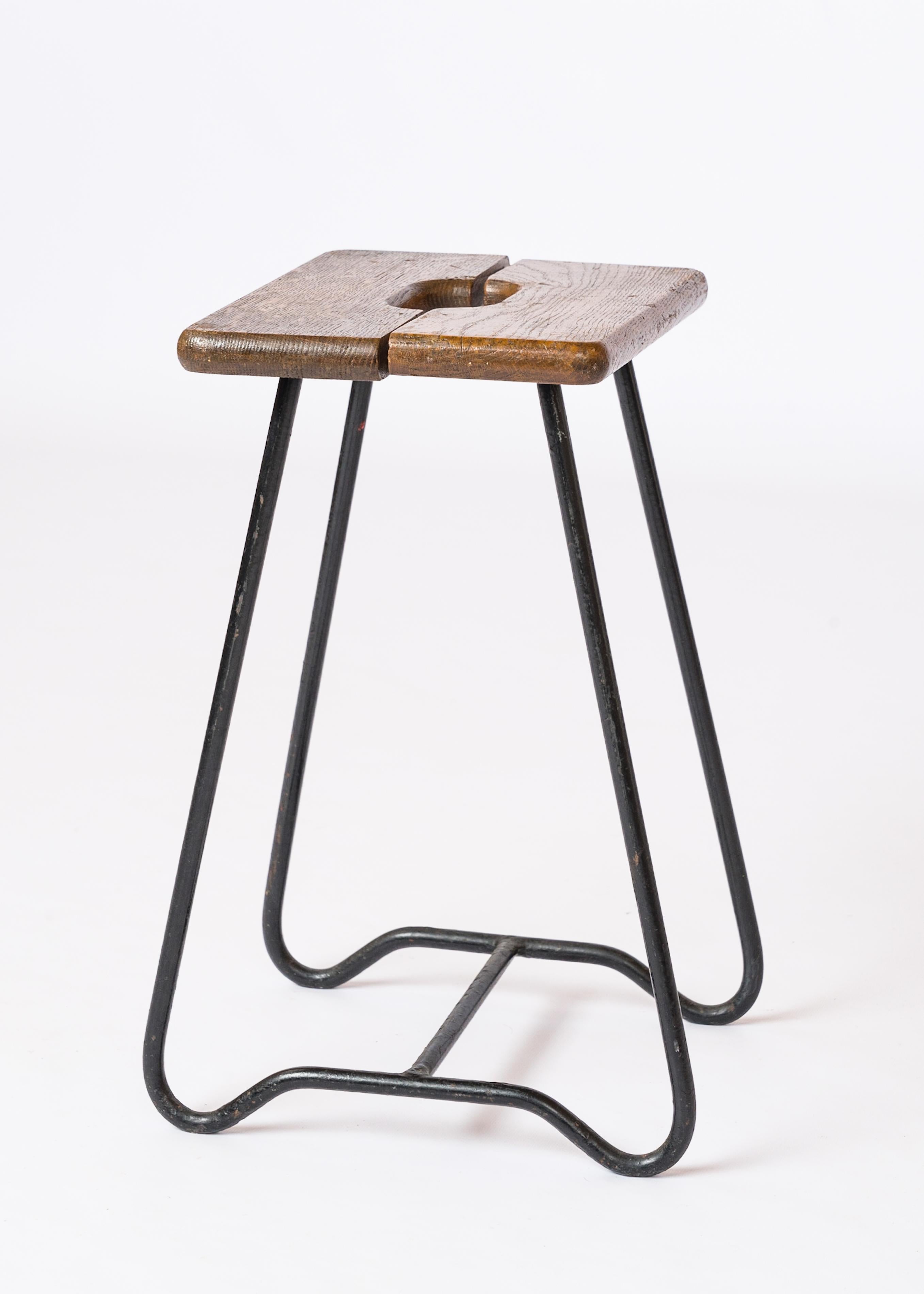 Elegante taburete de listones partidos de roble con asa incrustada. Base de hierro forjado al estilo de los asientos de la serie 