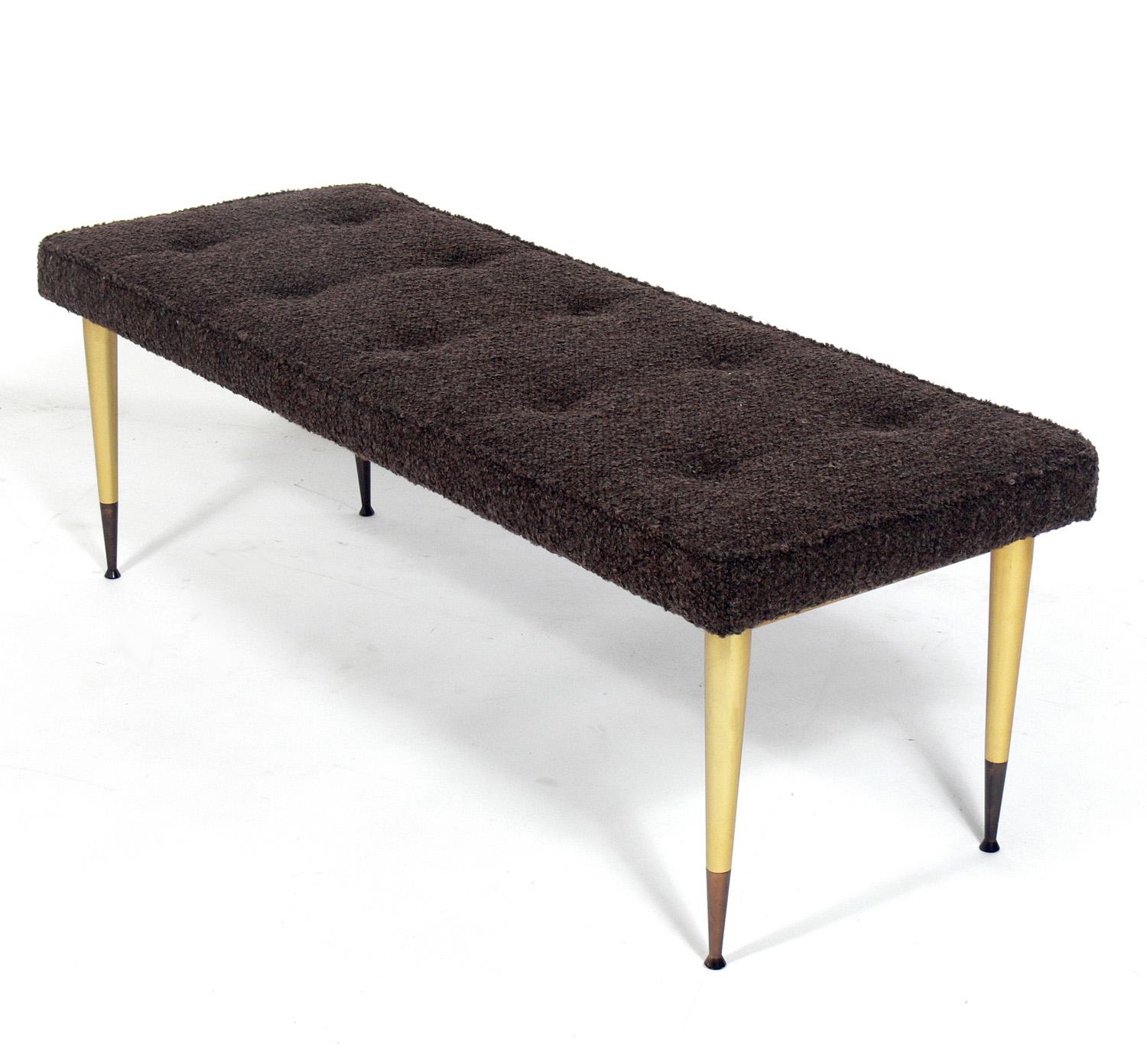 Modernist Italian bench, circa 1960s. Marked Made In Italy underneath. It is constructed of anodized aluminum with a brass color finish with bronze color feet. It has been reupholstered in a nubby brown fabric.