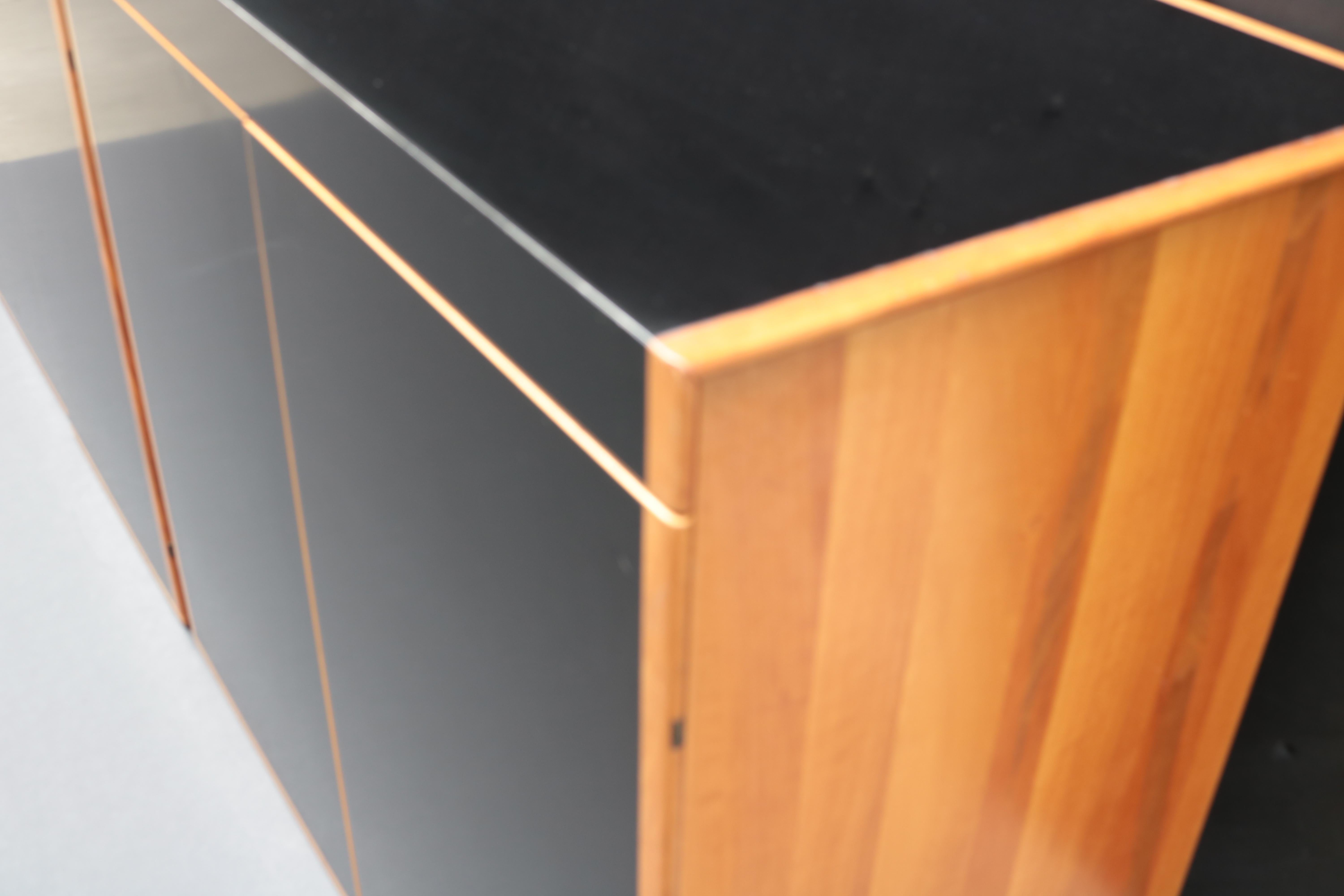 Armadio italiano modernista a quattro ante. 
Legno di ciliegio con piano e ante neri.